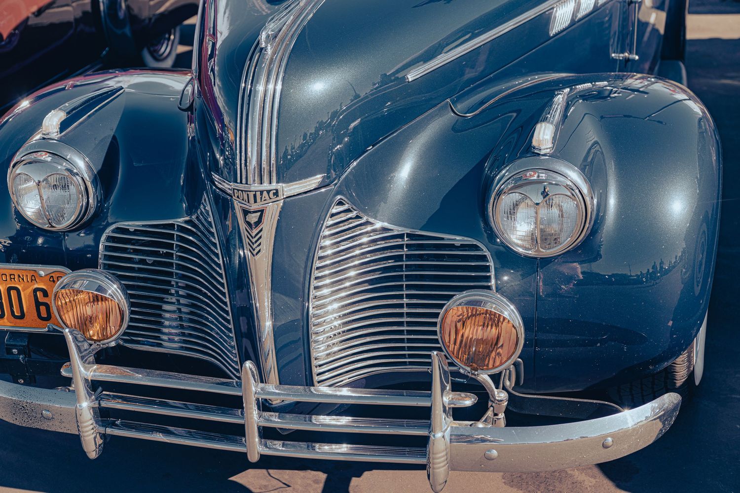 Front view of a restored vintage Buick classic car with chrome grille and amber parking lights.