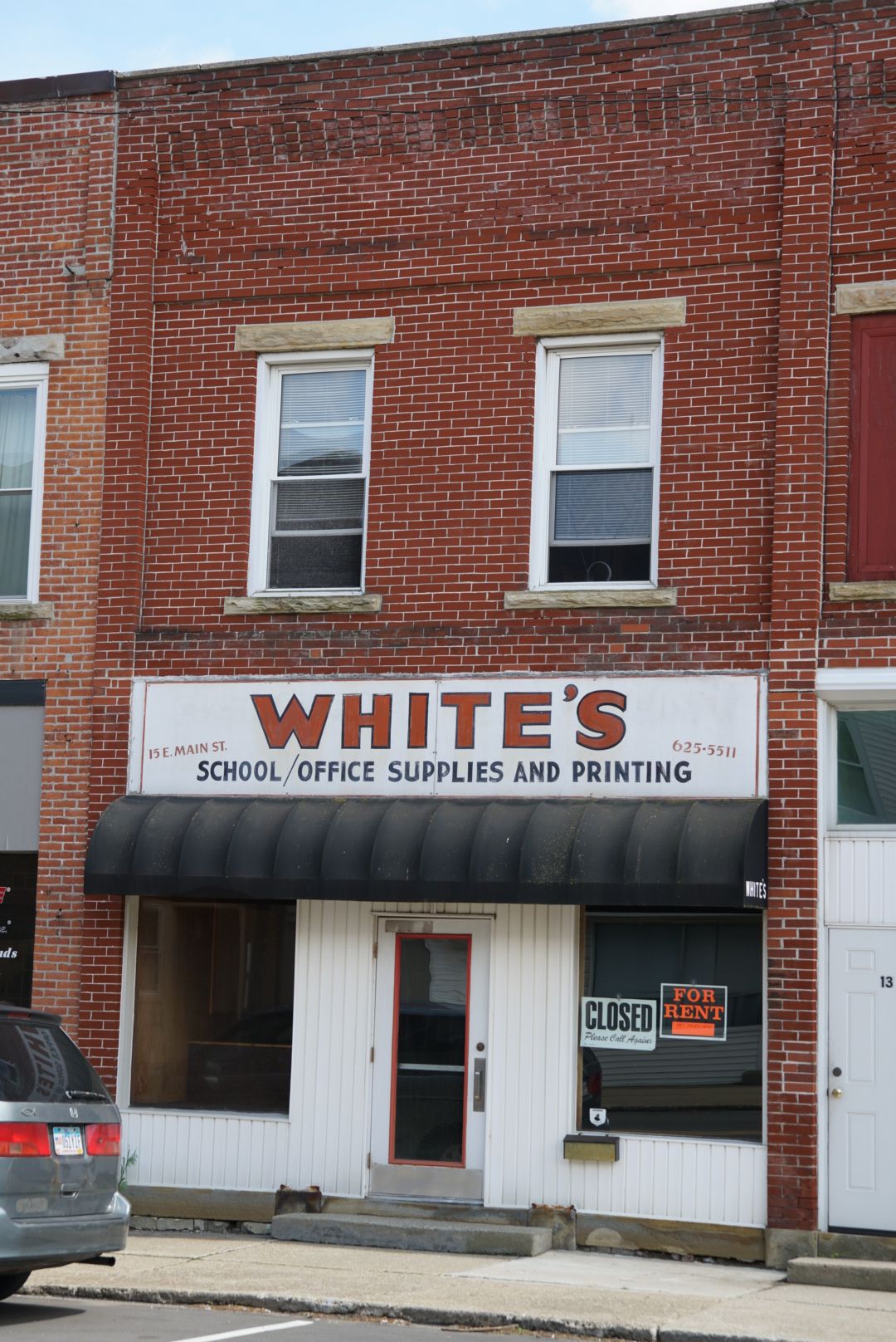 White's School Office Supplies and Printing store in a brick building on Main Street with a closed sign in the window.