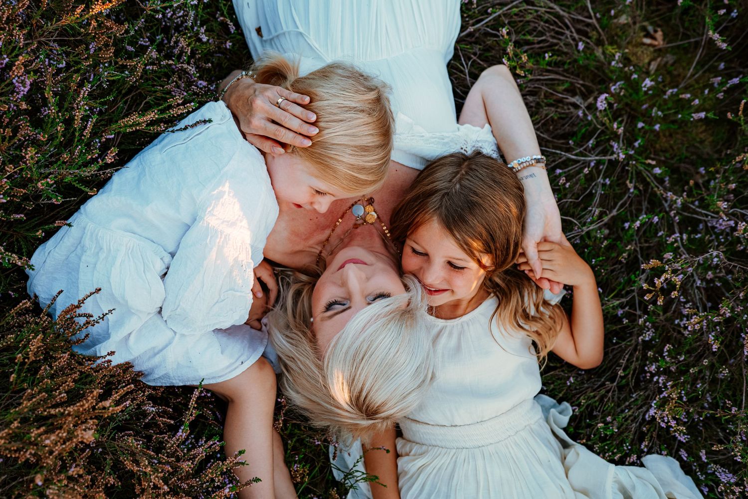 Candid overhead shot of a joyful family moment lying in a field.