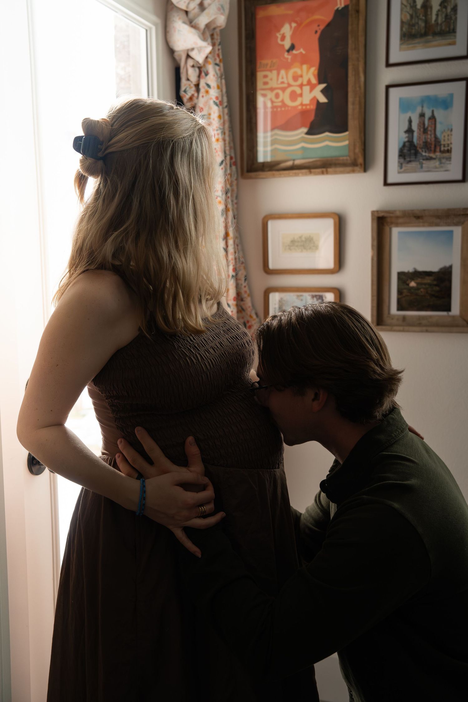 ©AnnaVonRiesenPhotography Maternity Portraits | Image of husband kissing wife's pregnant tummy.