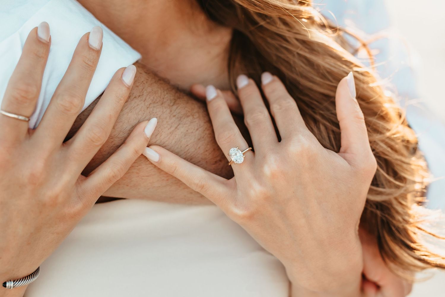 Hands gently touching and caressing hair in a sequence of intimate gestures against a light background.