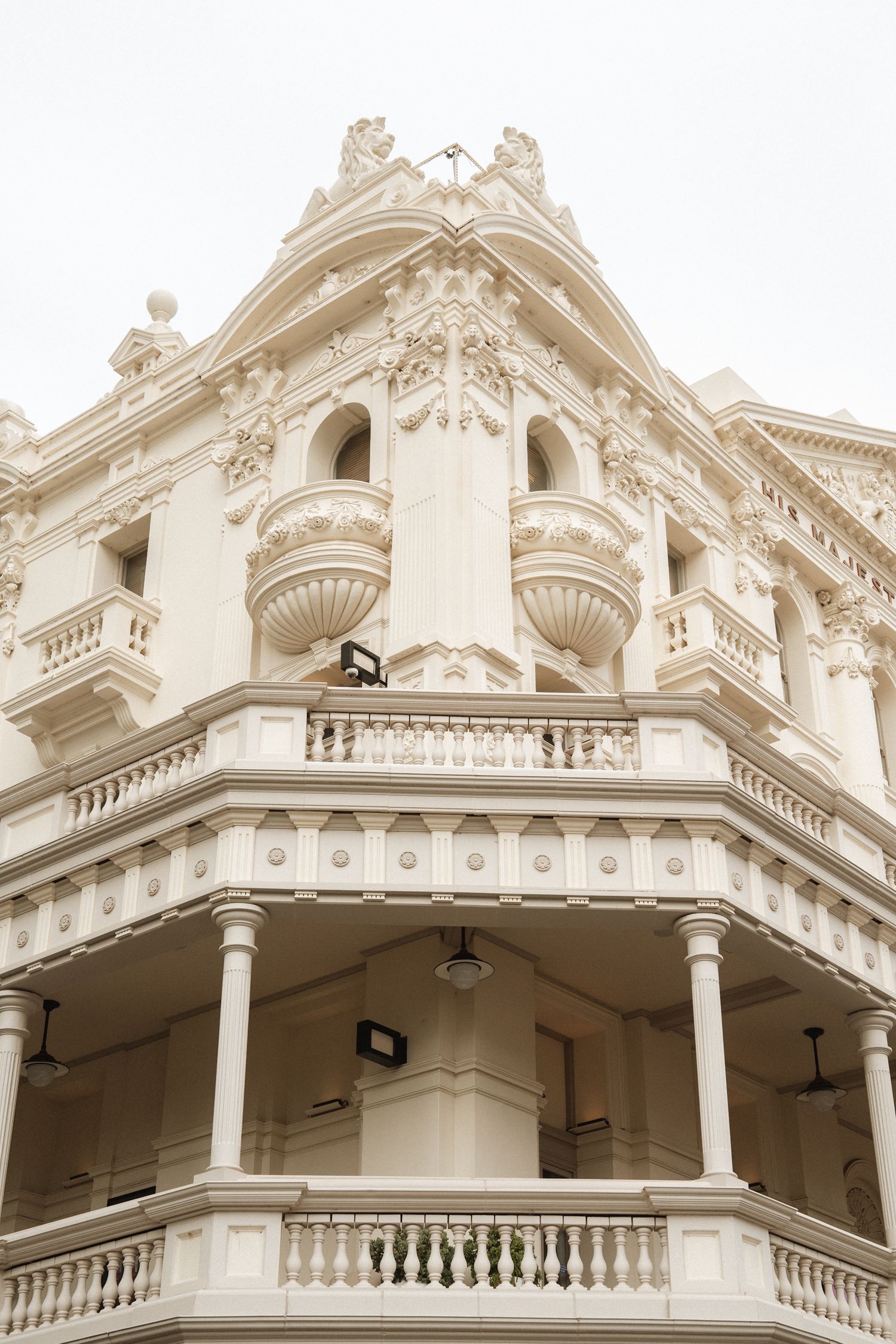 Ornate white Victorian-style architectural details showing decorative columns, balconies, and intricate moldings on a historic building.
