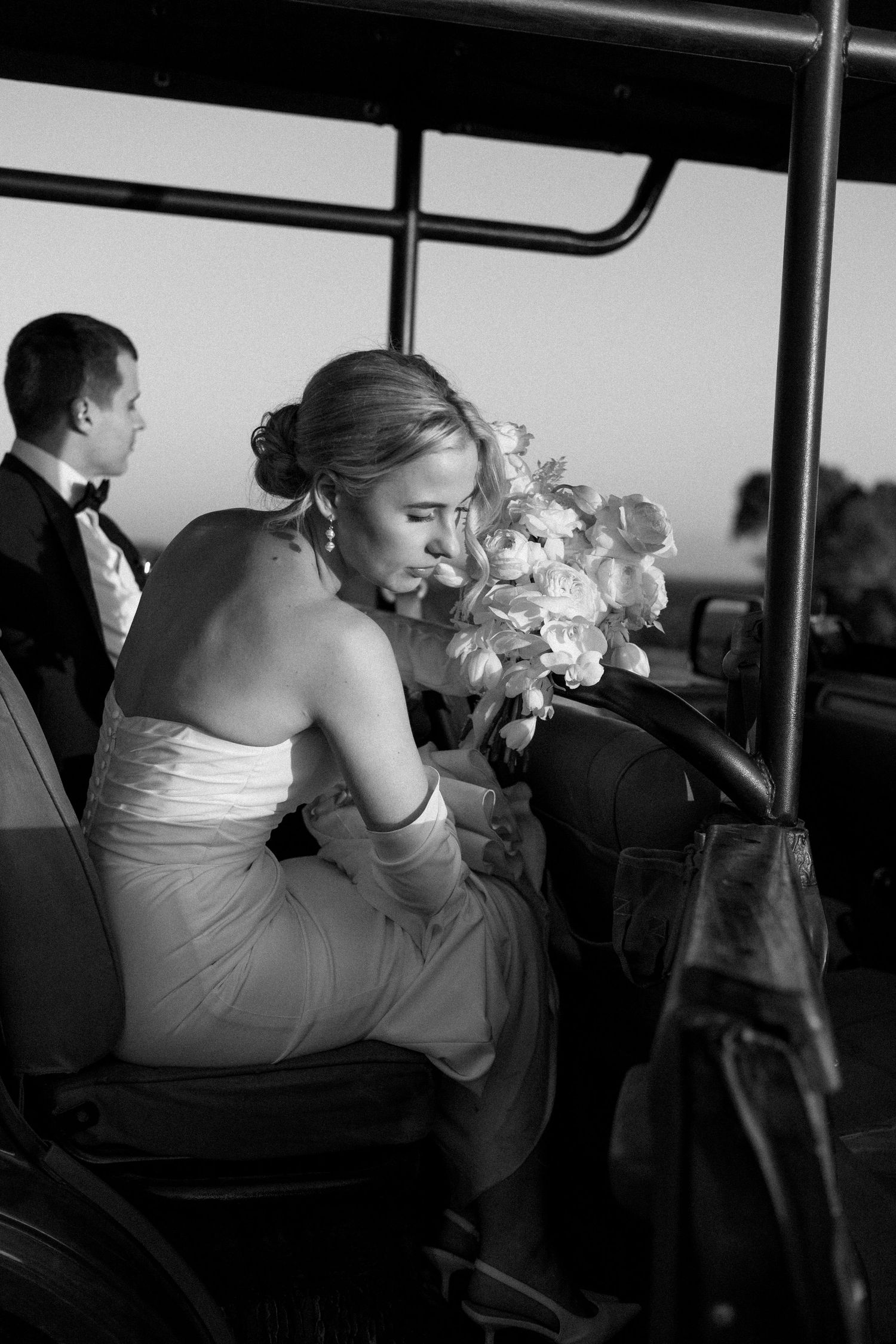 A black and white photo series shows a couple embracing in the back of a vehicle during what appears to be a wedding.