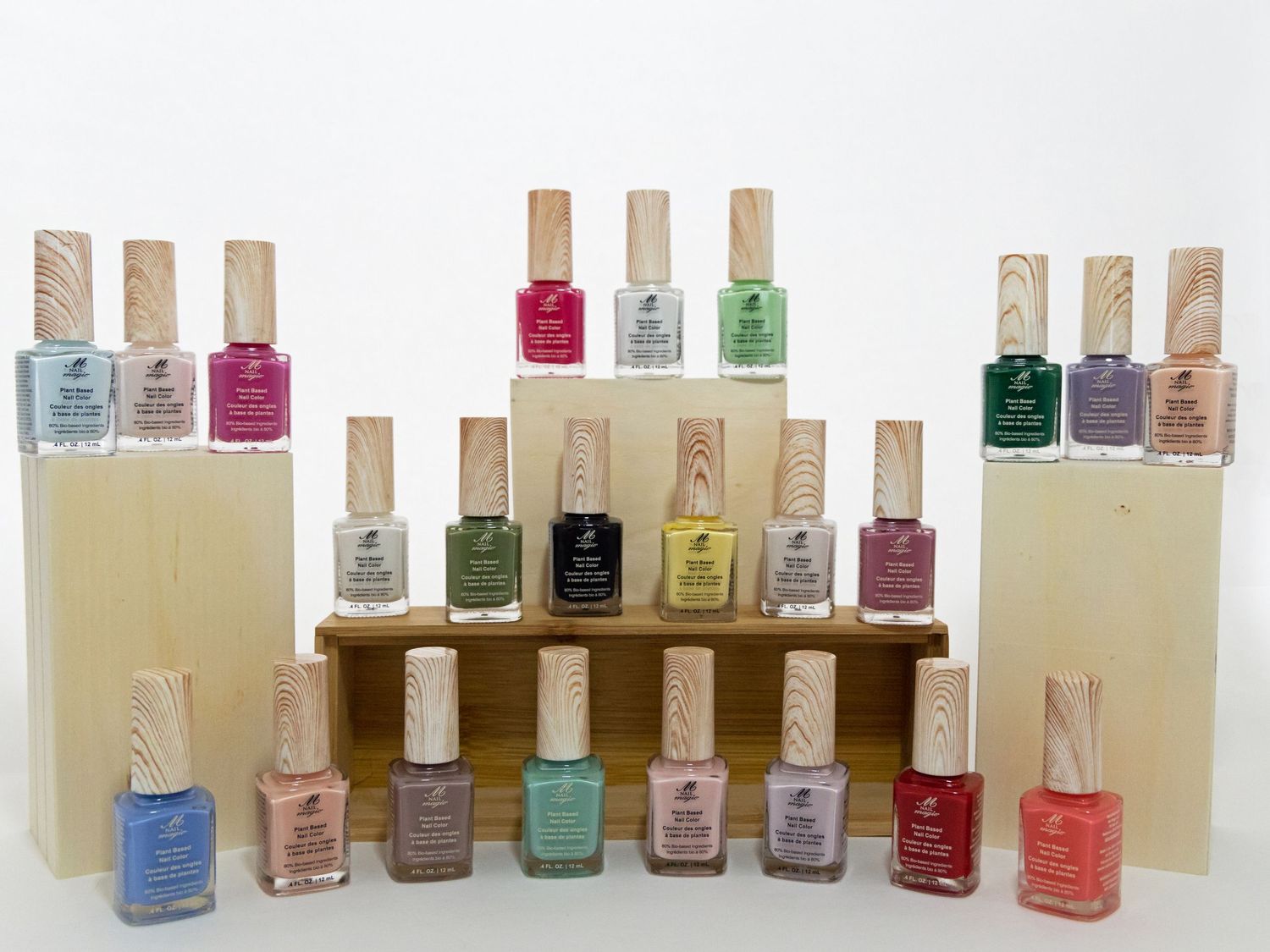 Large collection of pastel nail polishes arranged on cream and wooden display stands.