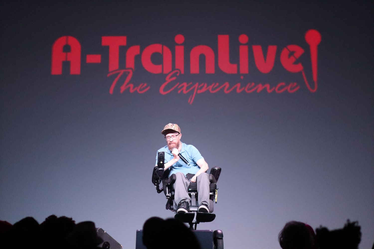 Performer in motorized wheelchair on stage at A-Train Live The Experience show.