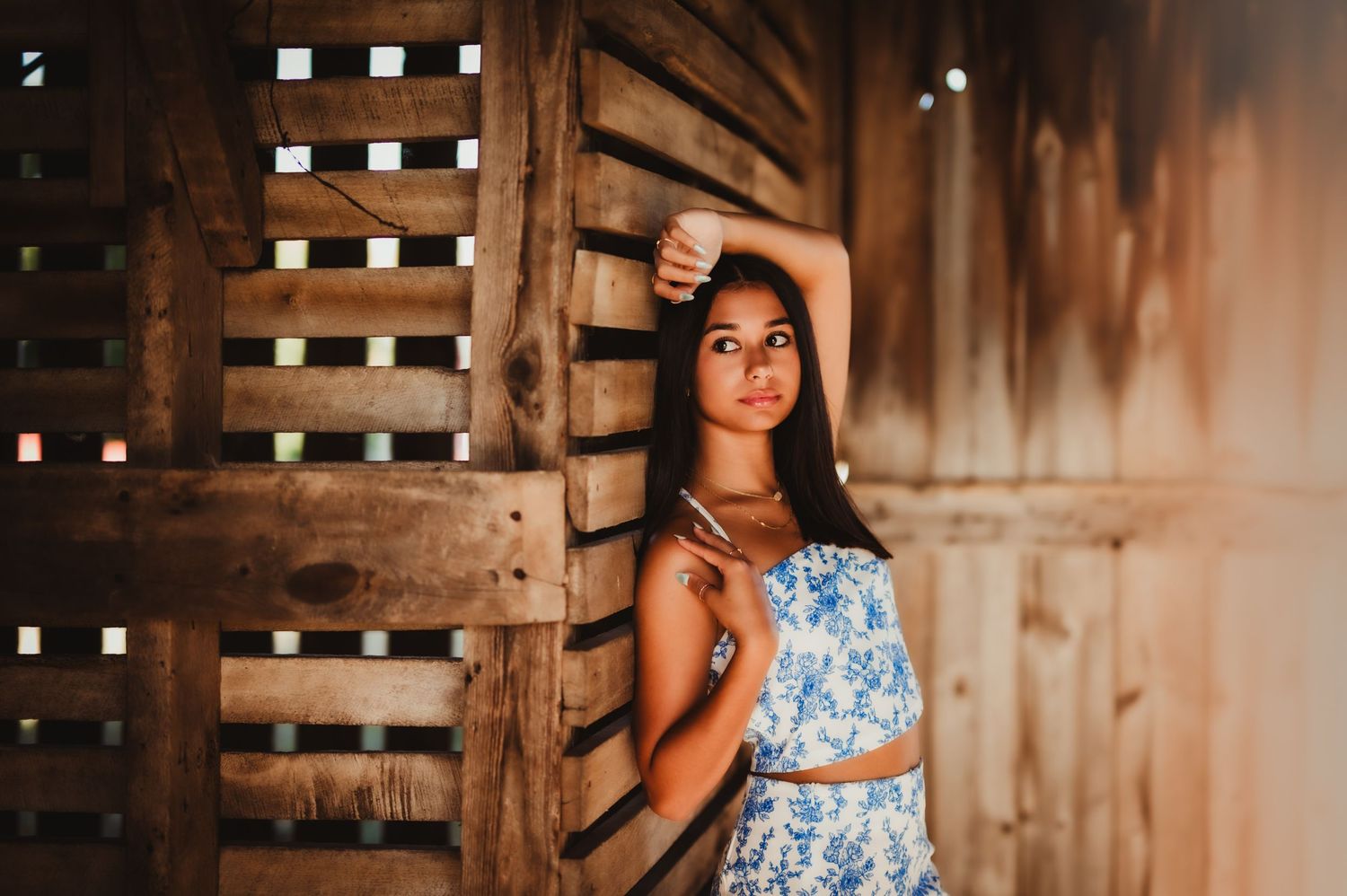 Indoor barn photoshoot with natural lighting and blue floral outfit.