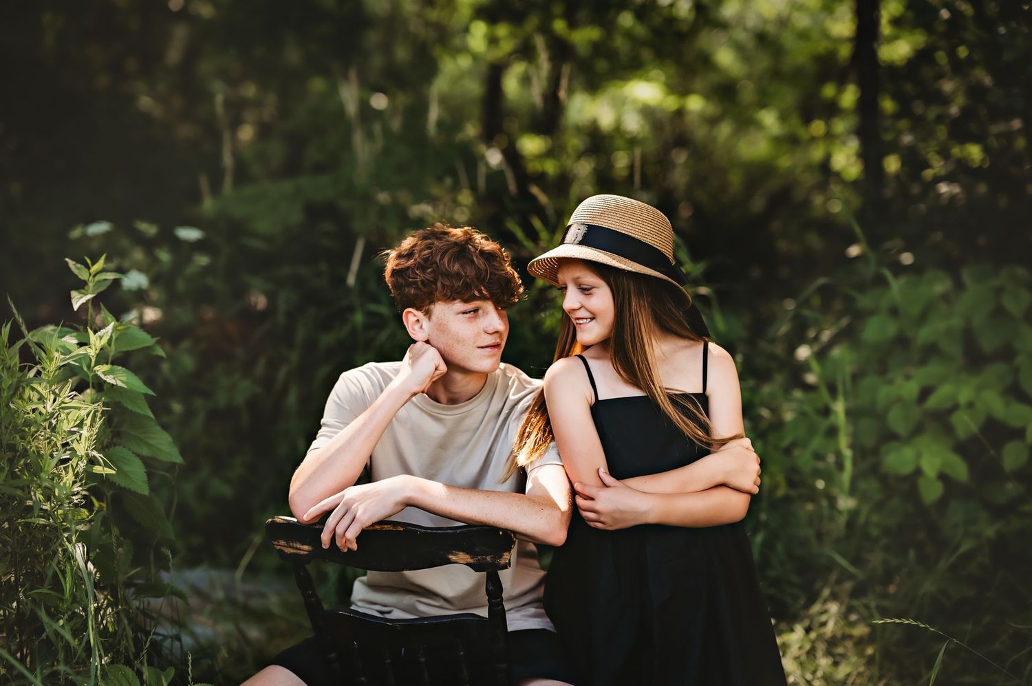 A couple embraces outdoors in a romantic photoshoot surrounded by lush green foliage in private outdoor Kewaskum, WI Creek Studio
