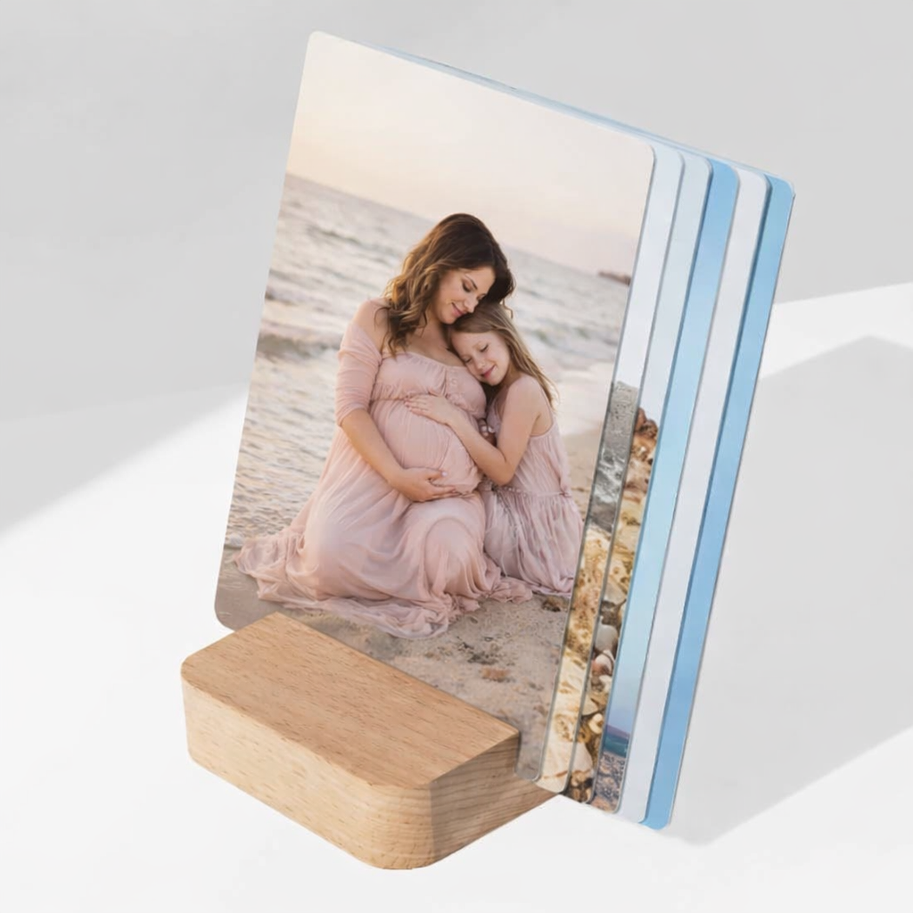 Personalized photo cards in a wooden stand featuring a maternity portrait of a woman and child on the beach.