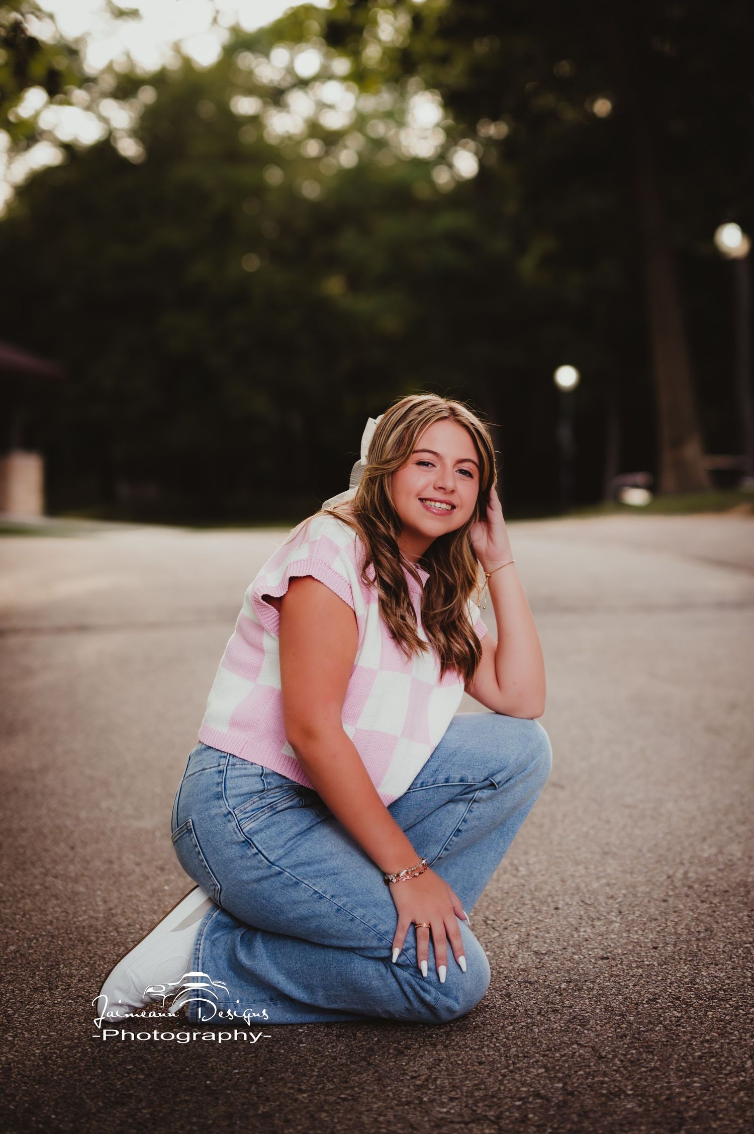 Casual portrait on asphalt wearing tie-dye shirt and jeans at sunset.
