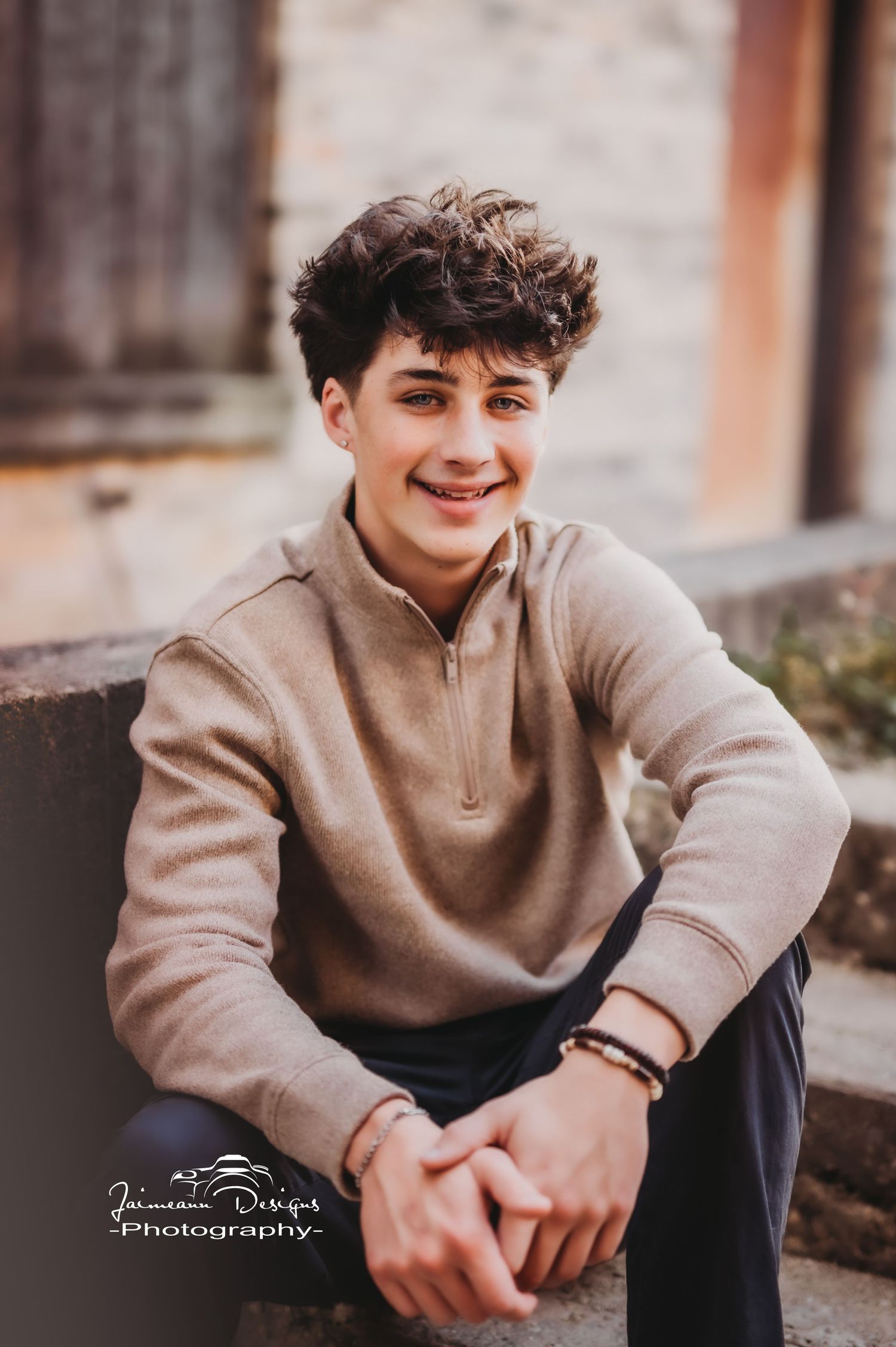 Casual outdoor portrait with beige quarter-zip sweater and relaxed pose on urban steps.