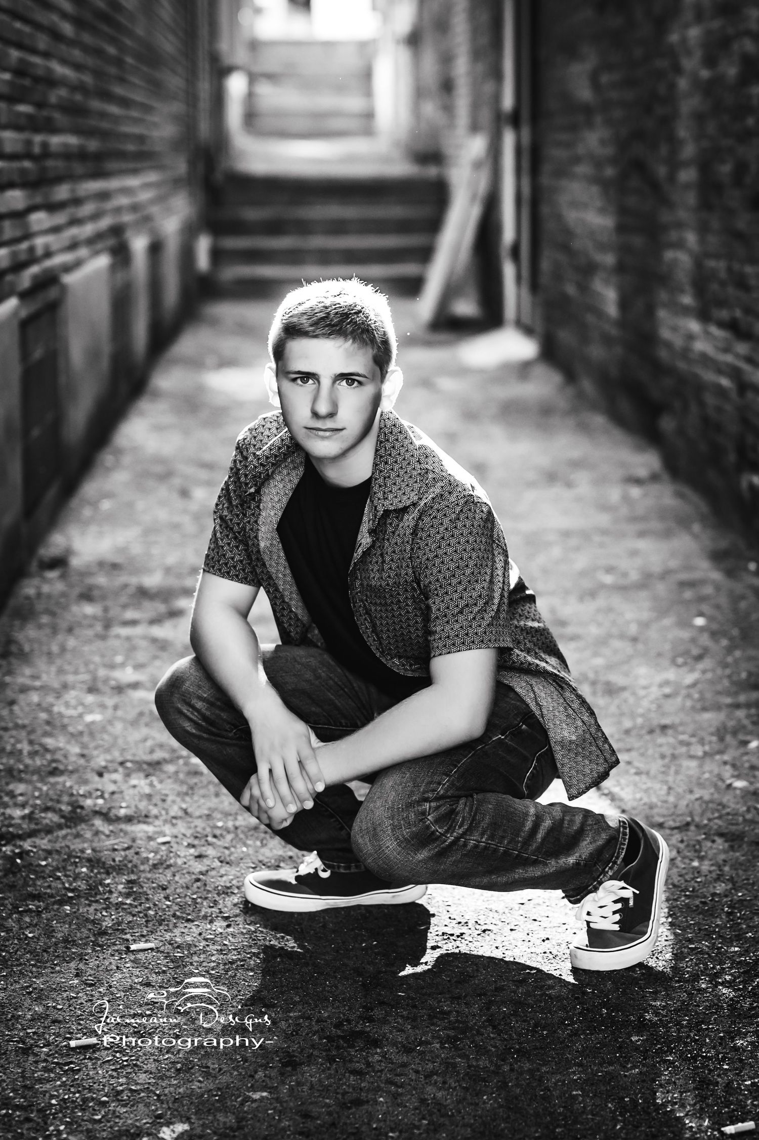 Black and white portrait in an urban alley with brick walls.