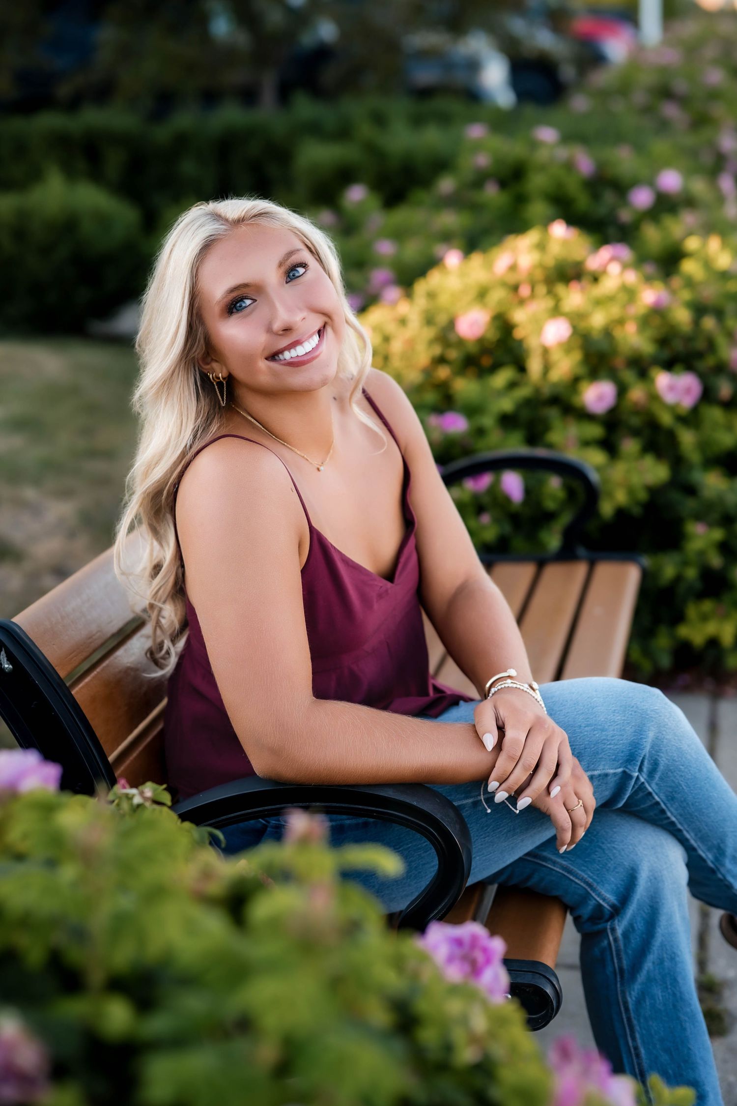 A senior girl sitting on a bench in Port Washington