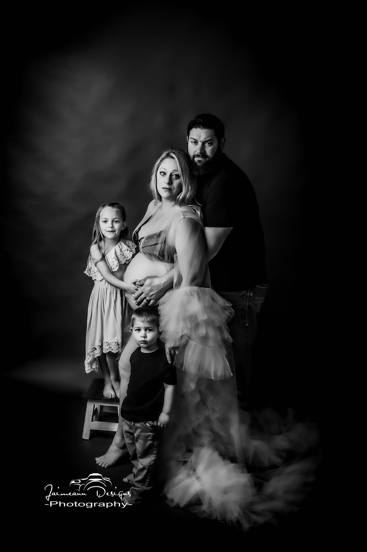 Dramatic black and white maternity studio portrait with smoke effects.