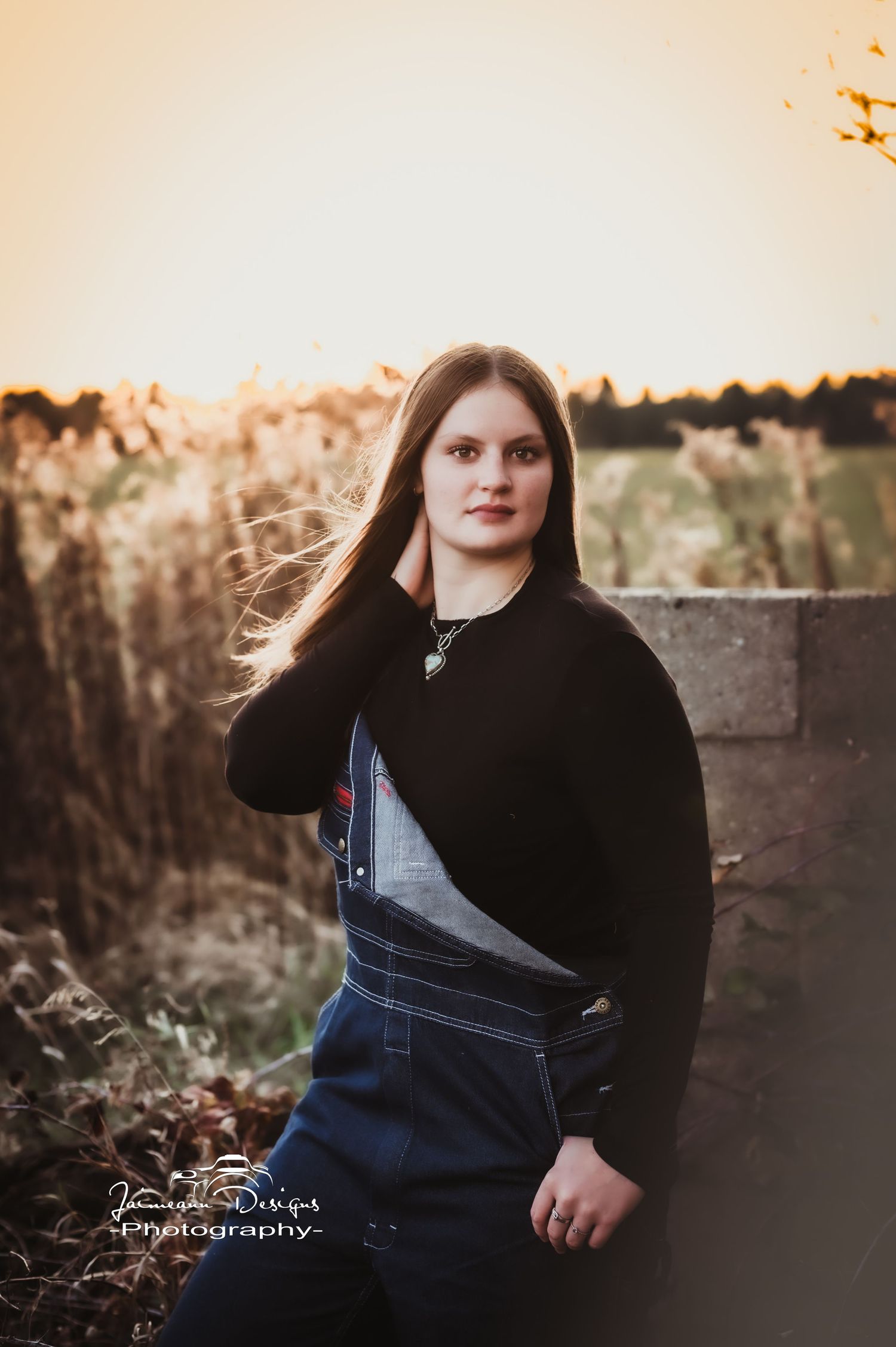 Sunset portrait with golden backlight and autumn field backdrop.