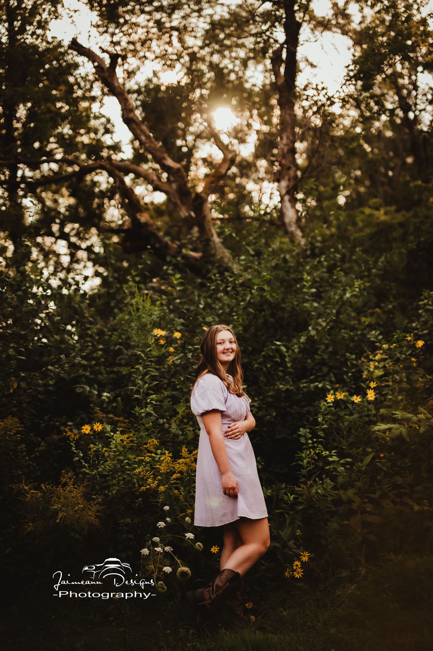 A white dress stands out against a wooded backdrop at golden hour with sunlight filtering through the trees.