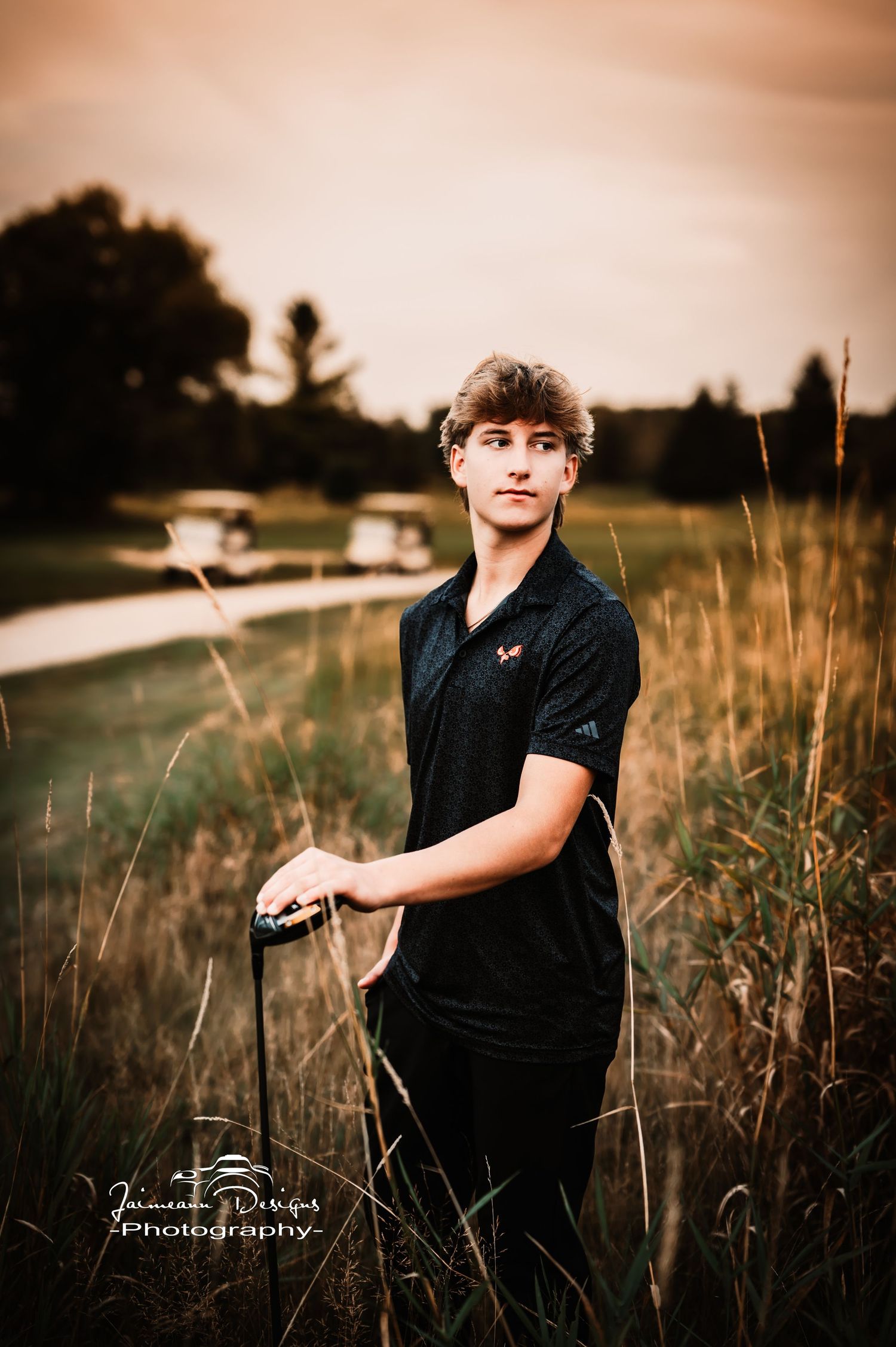 Portrait on golf course with tall grass and warm sunset lighting.