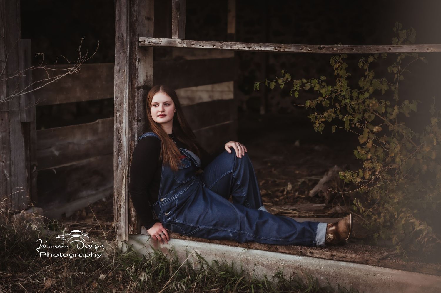 Relaxed portrait on wooden ledge of rustic barn structure.