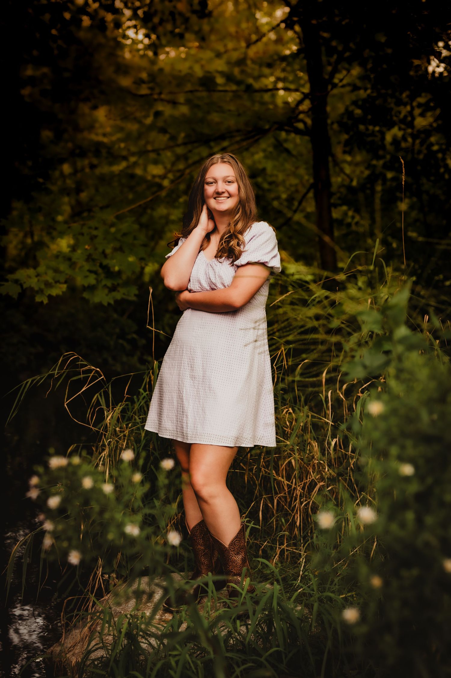 Outdoor portrait in white dress among wildflowers and natural scenery.