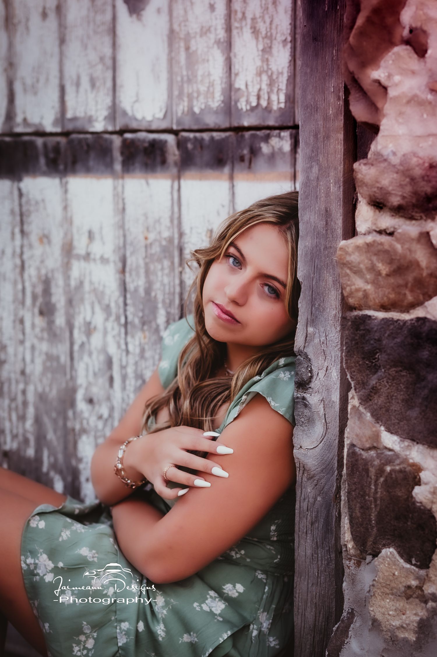 A candid portrait against weathered wood and stone wall featuring a mint green dress.
