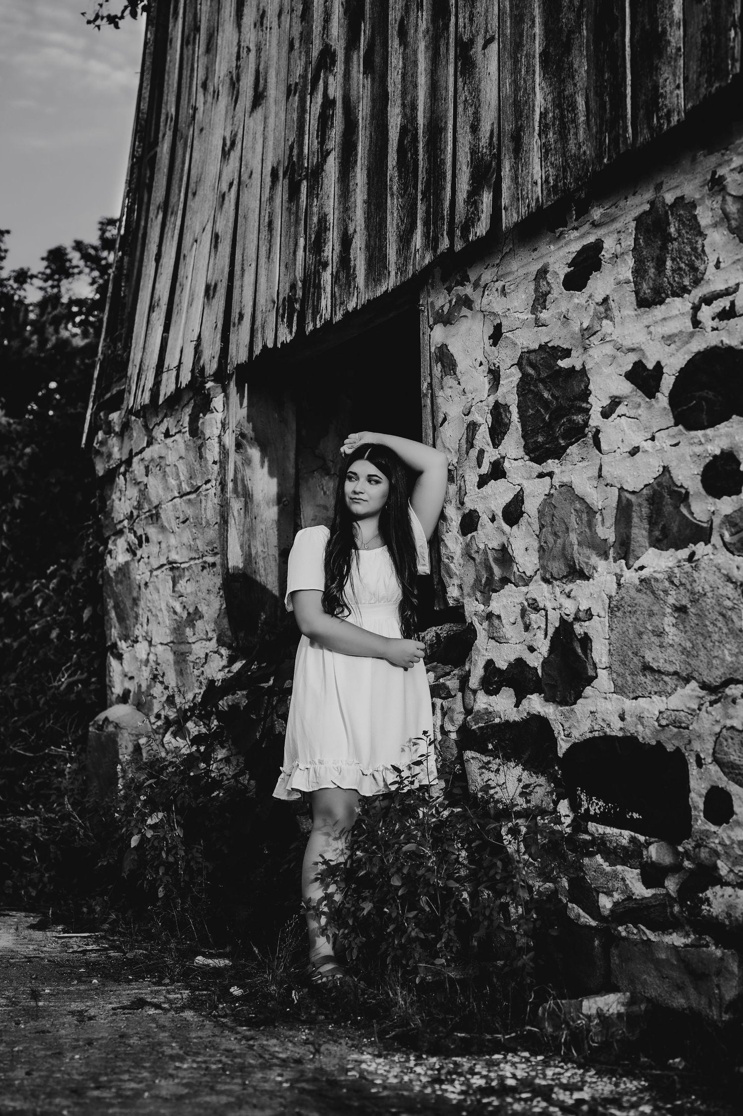 Black and white portrait featuring rustic stone and wooden barn architecture.