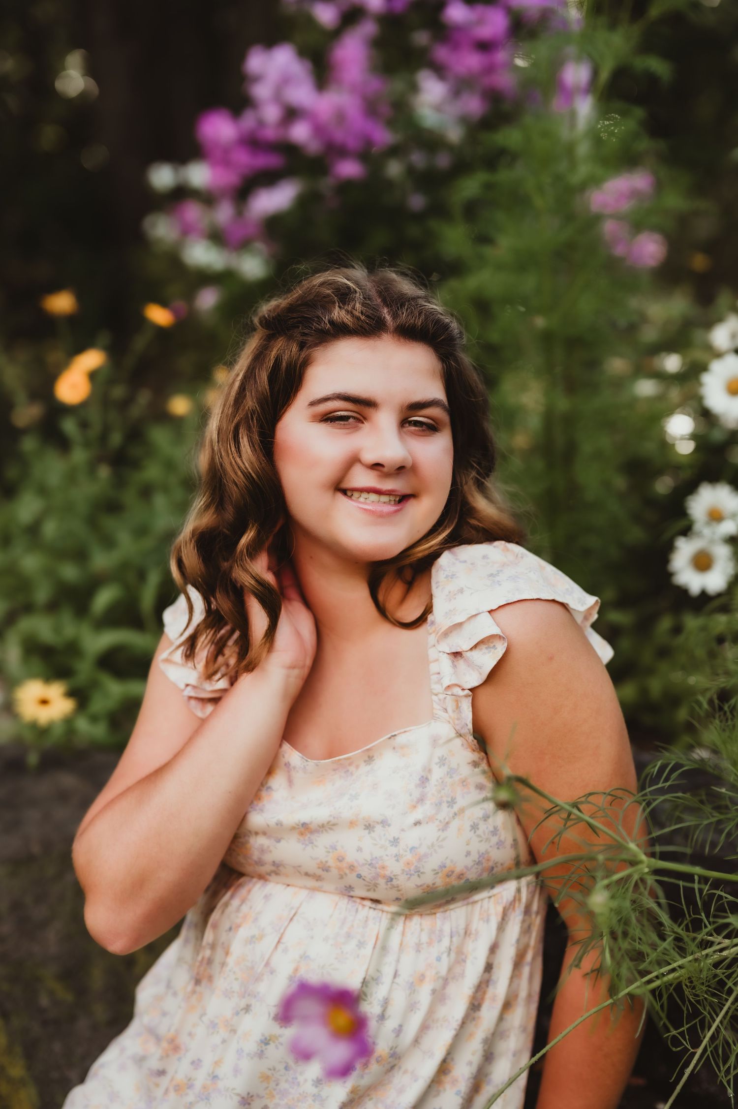 Summer portrait in a garden setting with vibrant purple flowers and daisies.