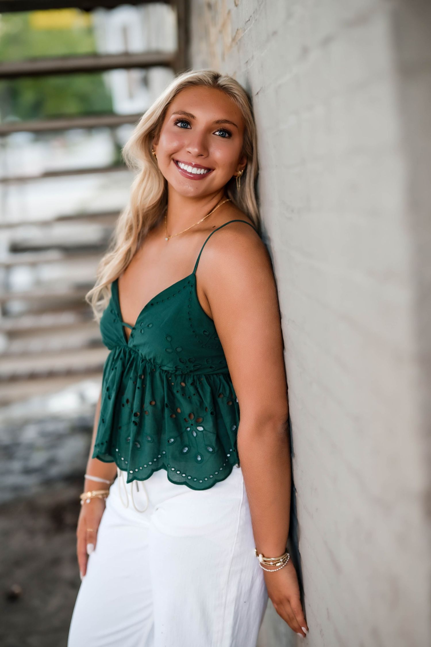 Senior girl leaning against a brick wall in downtown Port Washington