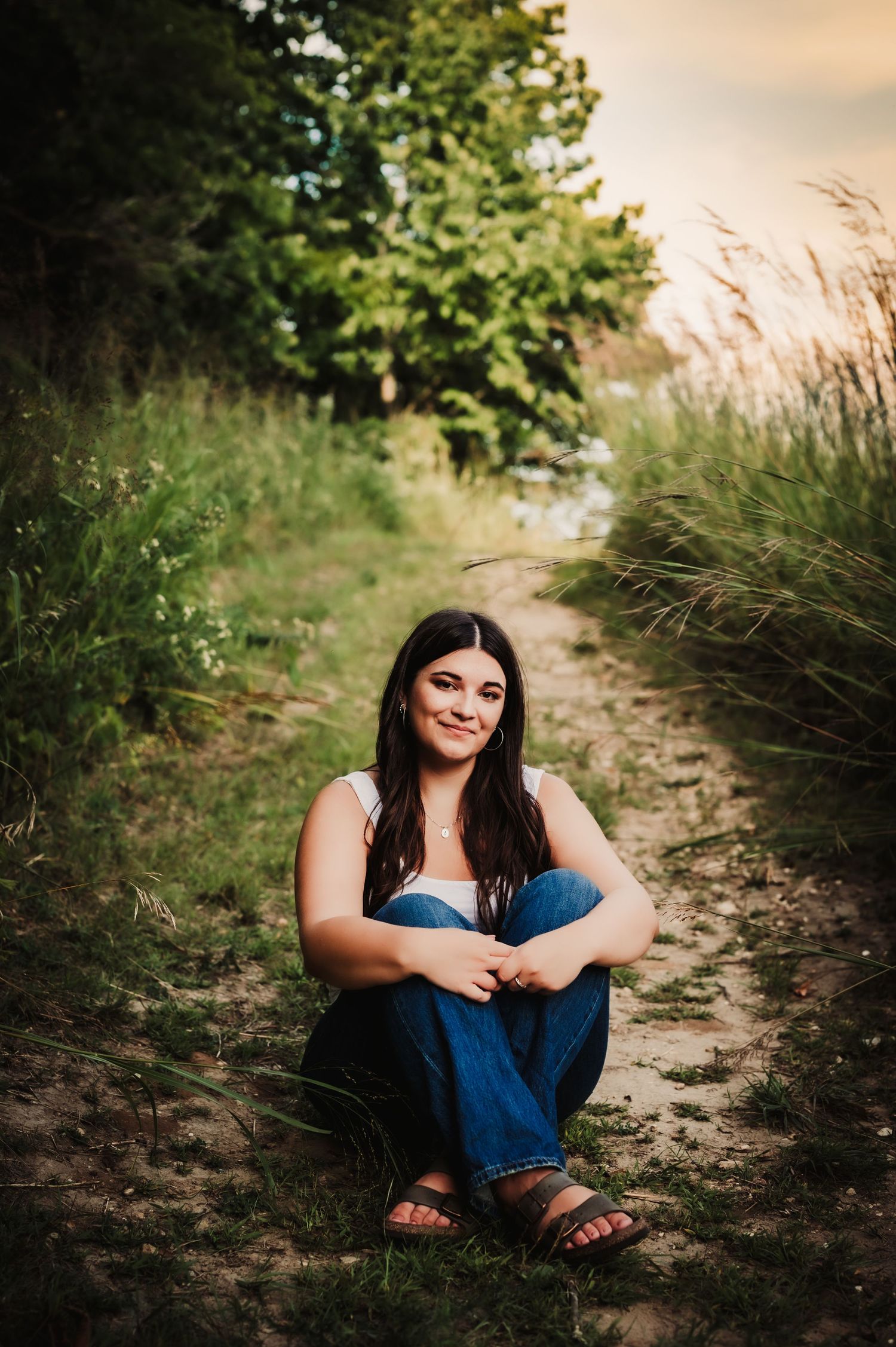 Casual portrait on dirt path surrounded by tall summer grasses.