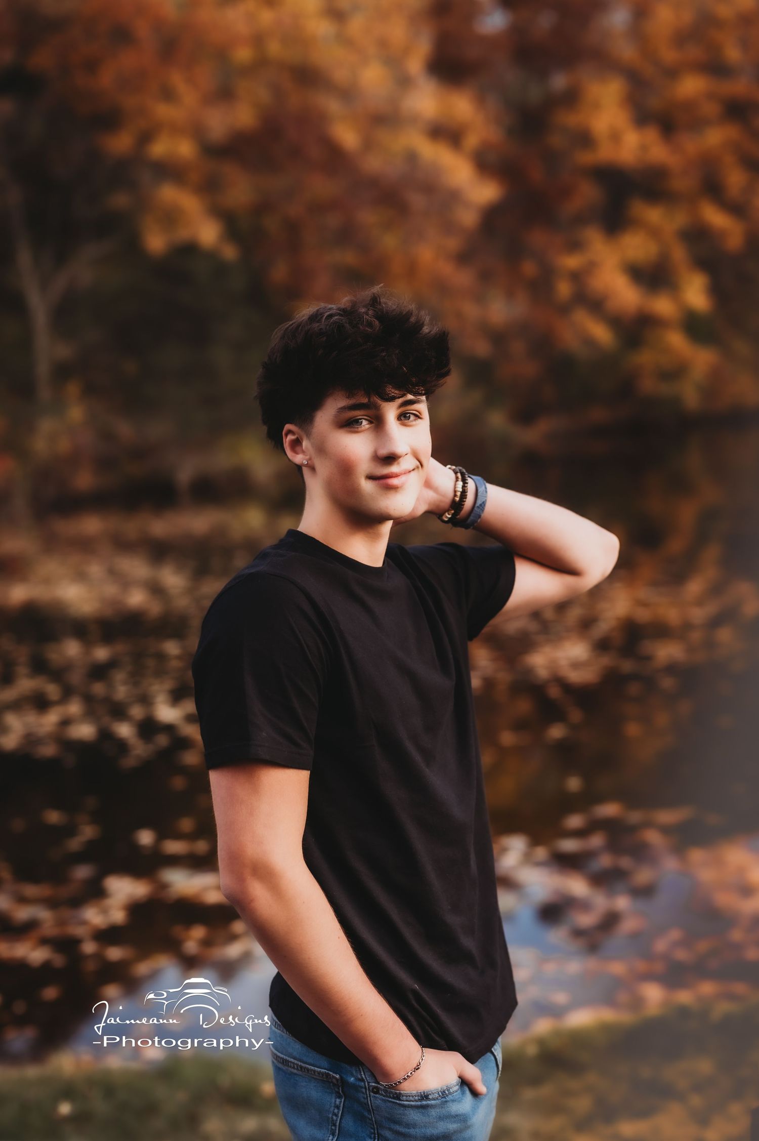 Casual outdoor portrait with warm autumn colors in background and black t-shirt outfit.