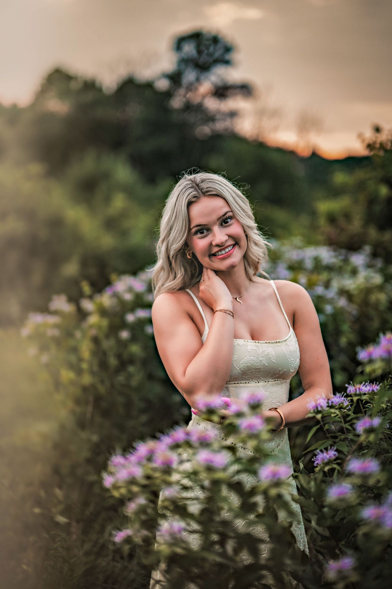 A golden sunset photoshoot in a meadow with purple wildflowers creates a dreamy summer evening atmosphere. Senor Photos in Menomonee Falls,