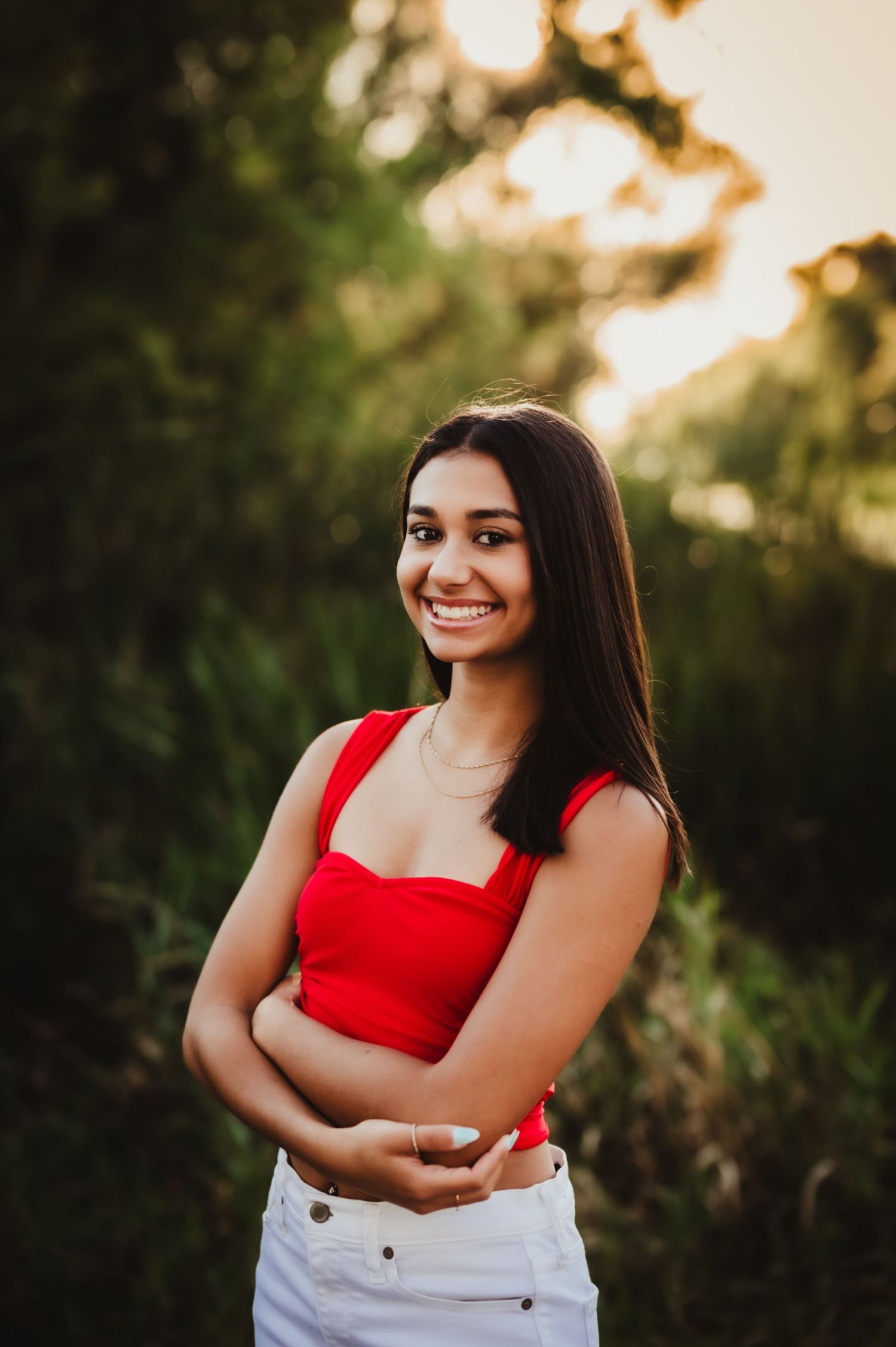 Summer fashion portrait in a red top against a natural sunset backdrop.