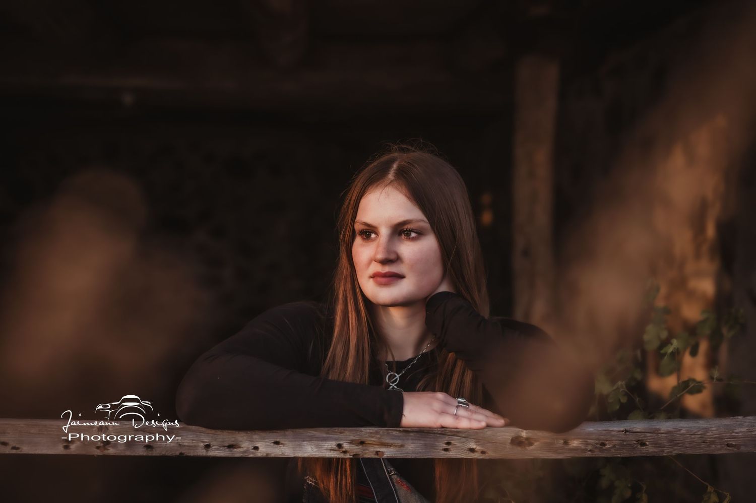 Close-up portrait through wooden fence with soft bokeh effect.