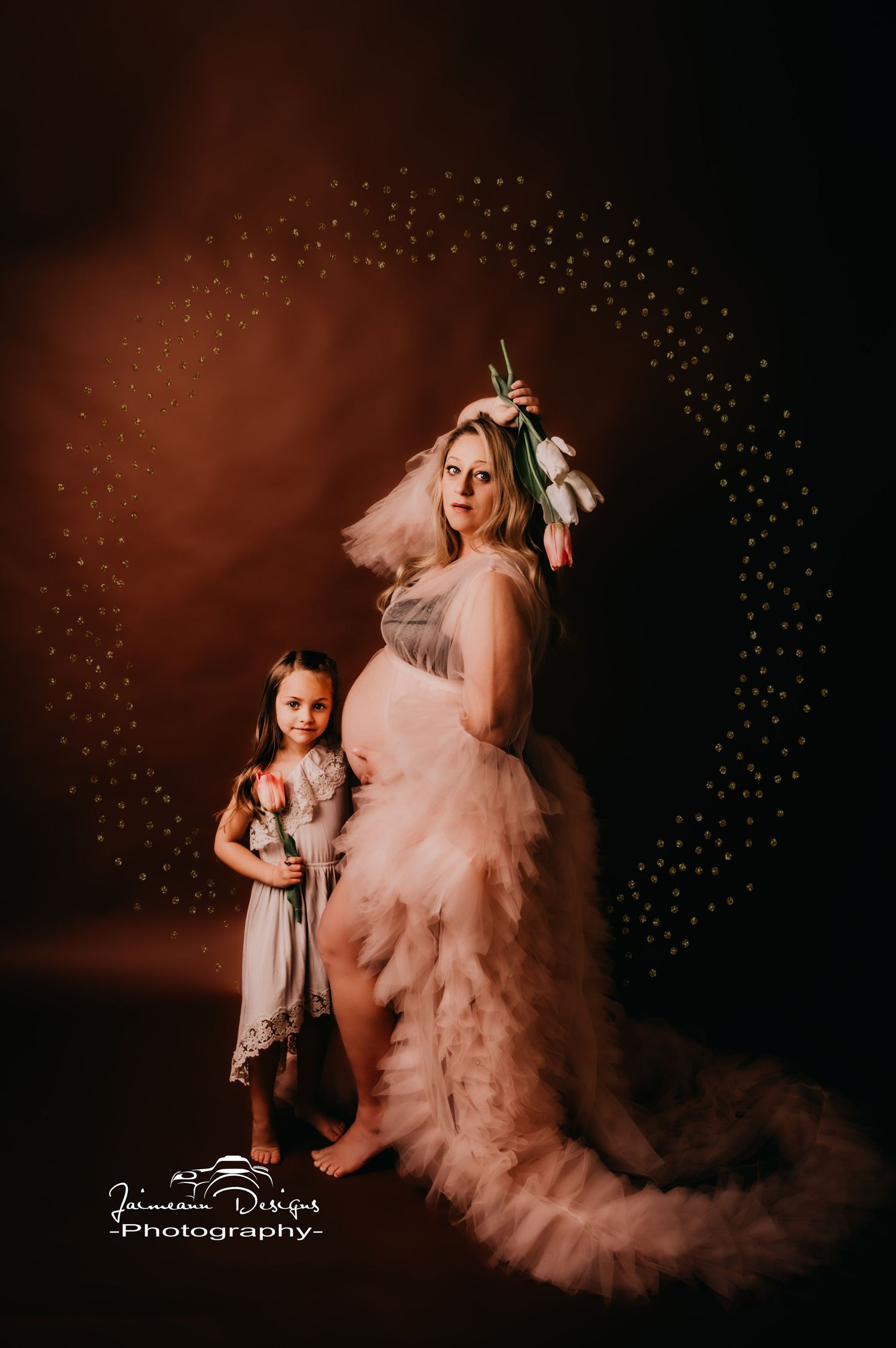 Ethereal maternity portrait with pink gown and magical sparkle effects.