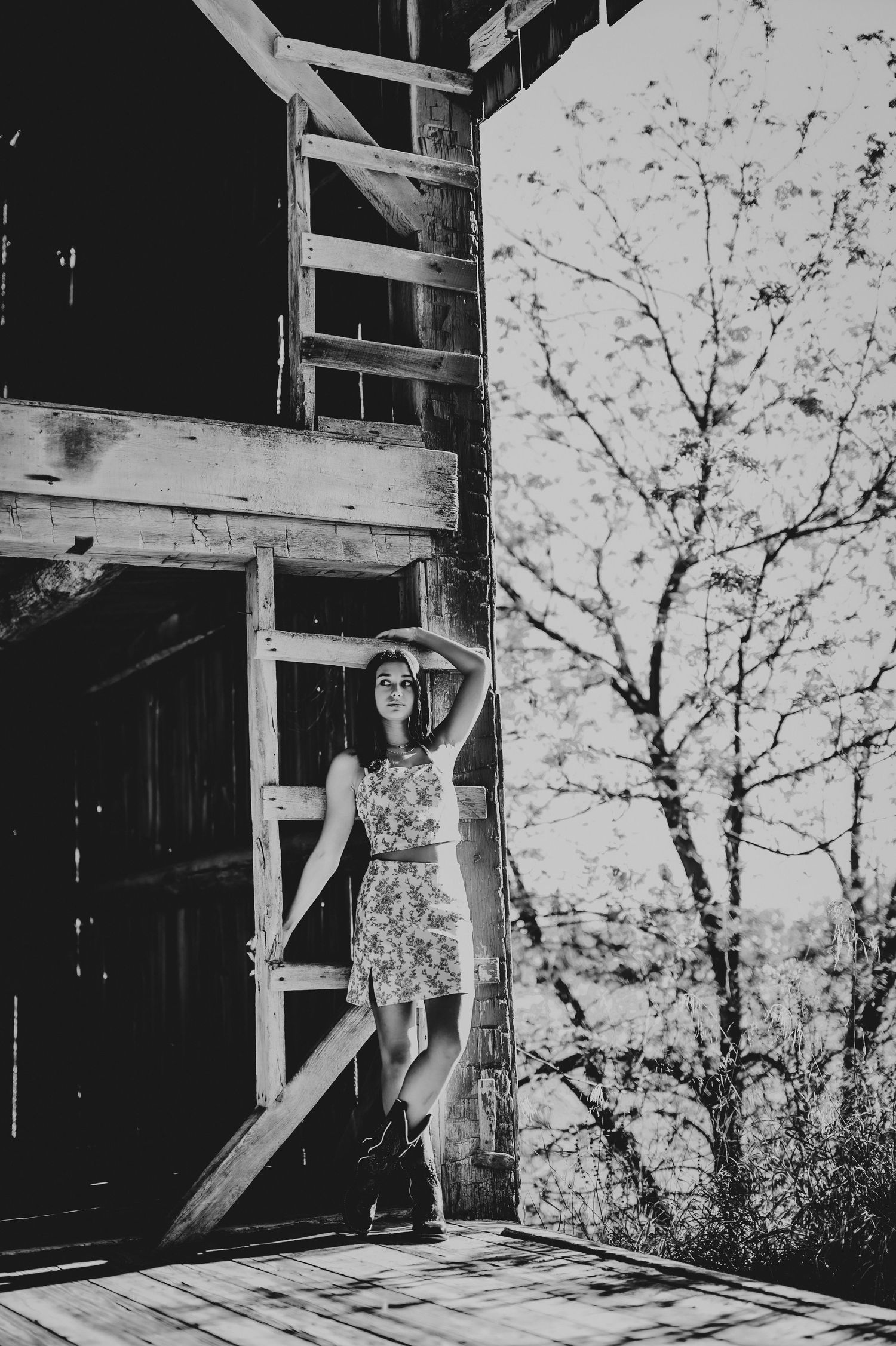 A vintage monochrome photo of a summer dress against rustic barn door framing.