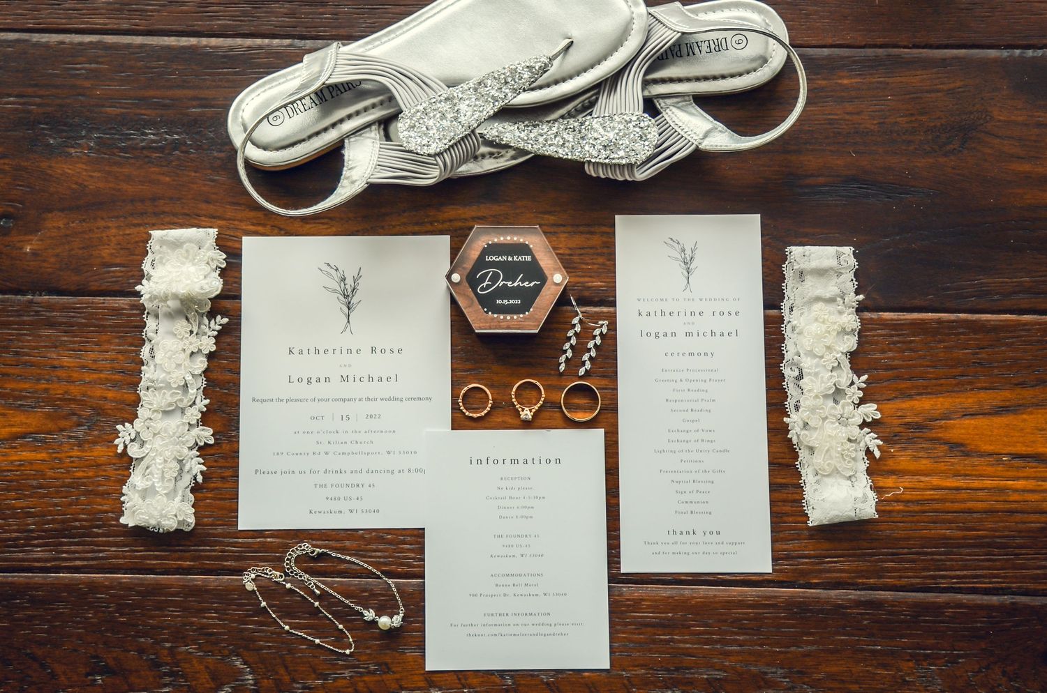 Wedding invitation suite with elegant typography laid out on dark wooden surface.