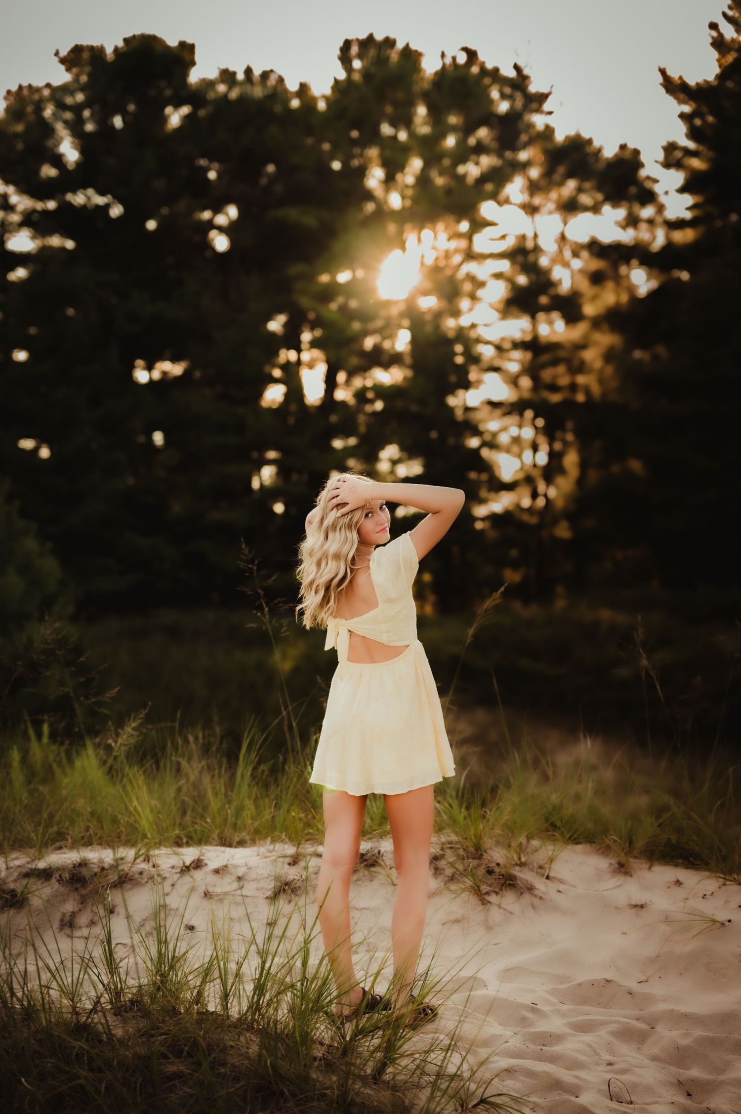 Silhouette of a white dress against a sunset through pine trees on a sandy beach dune, Sheboygan, WI