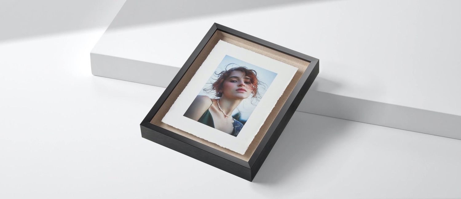 A framed portrait photo of a woman displayed in a black and gold picture frame on a white surface.