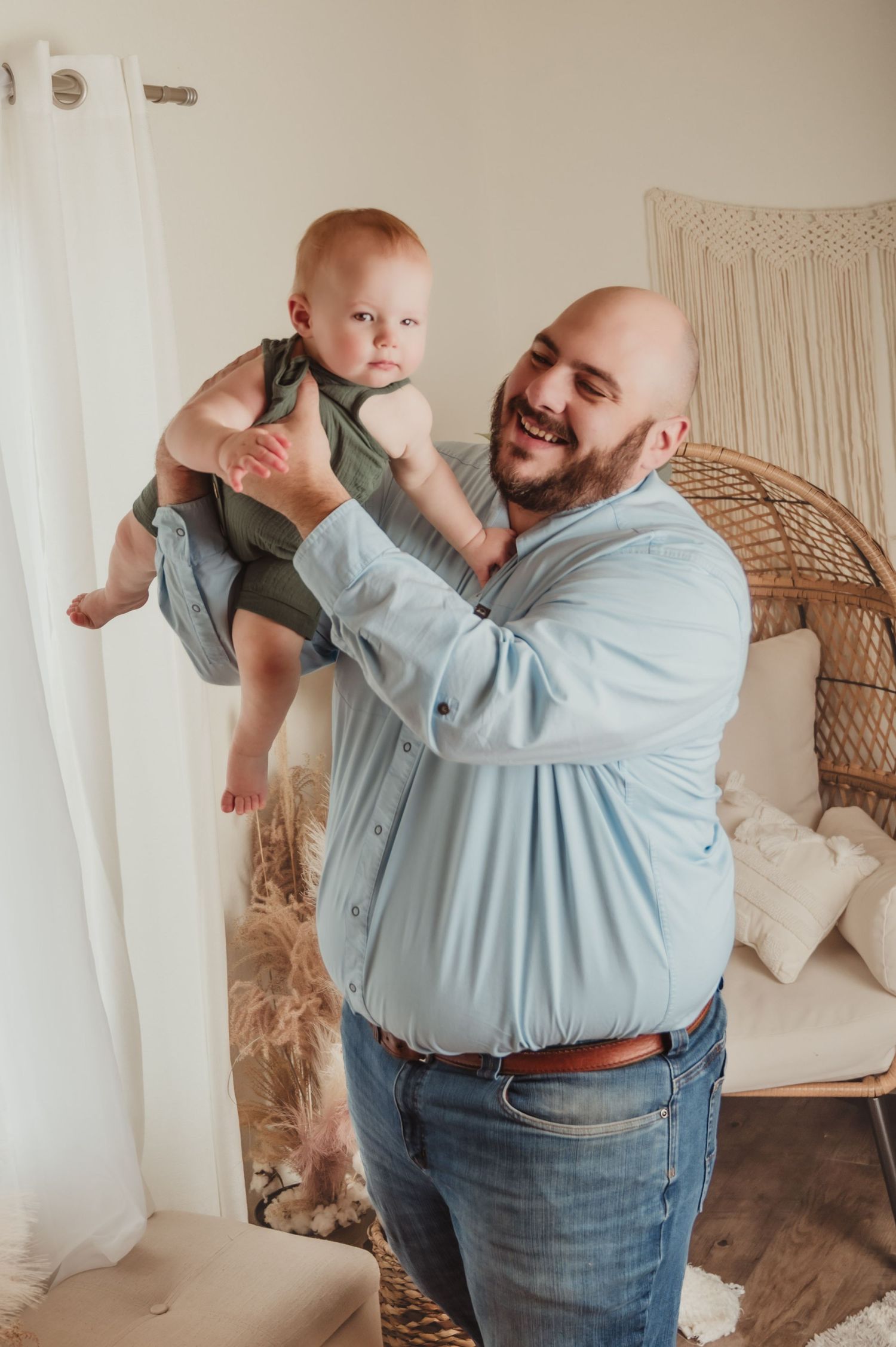 A joyful moment between parent and baby in a bright, boho-styled nursery setting.