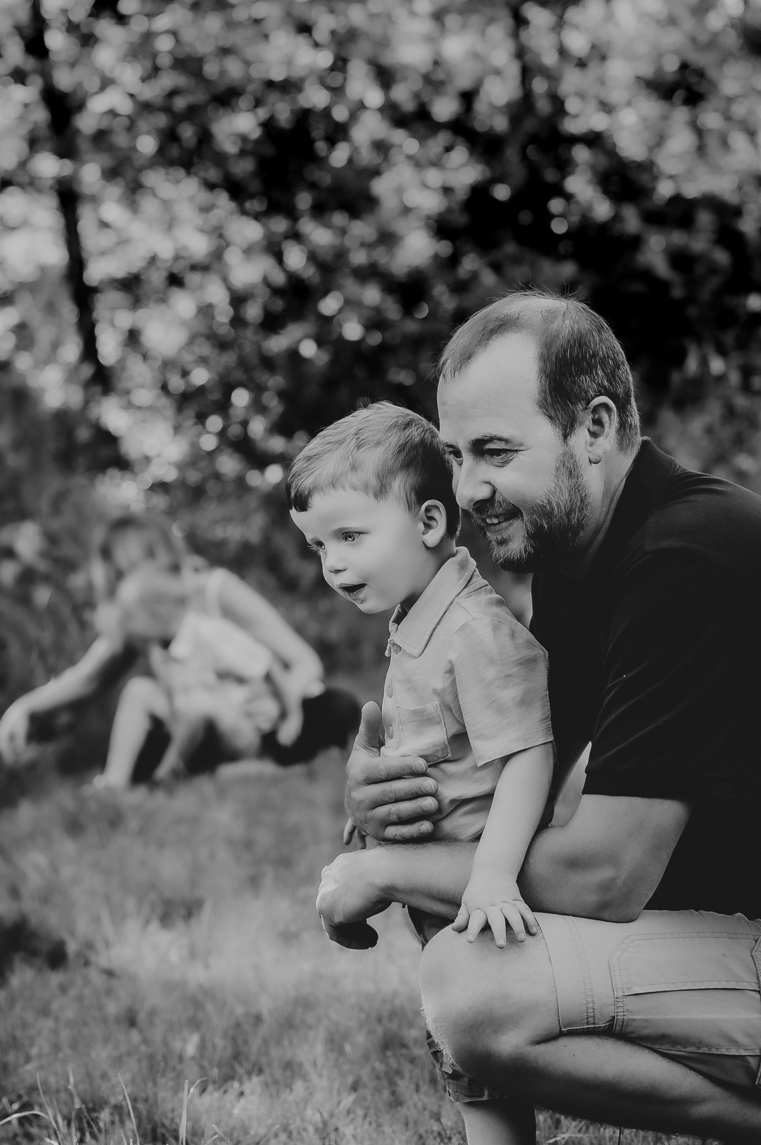 Black and white portrait of tender moment between parent and child outdoors.