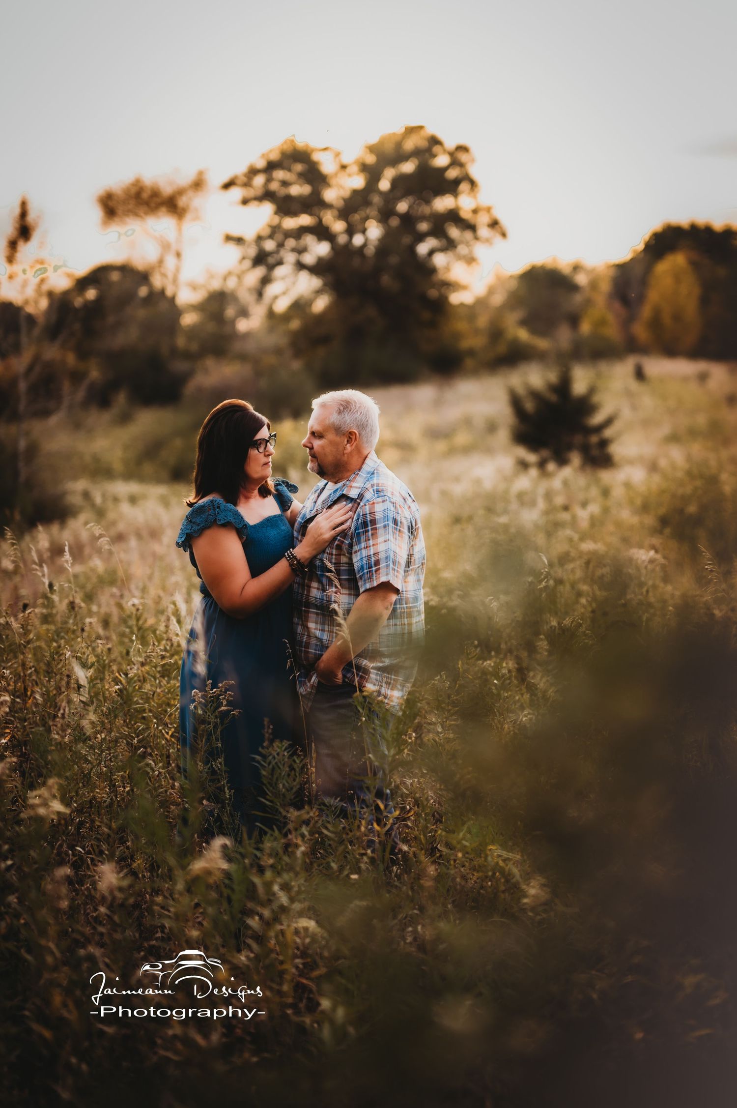 Couple sharing romantic moment in wildflower field during golden hour.
