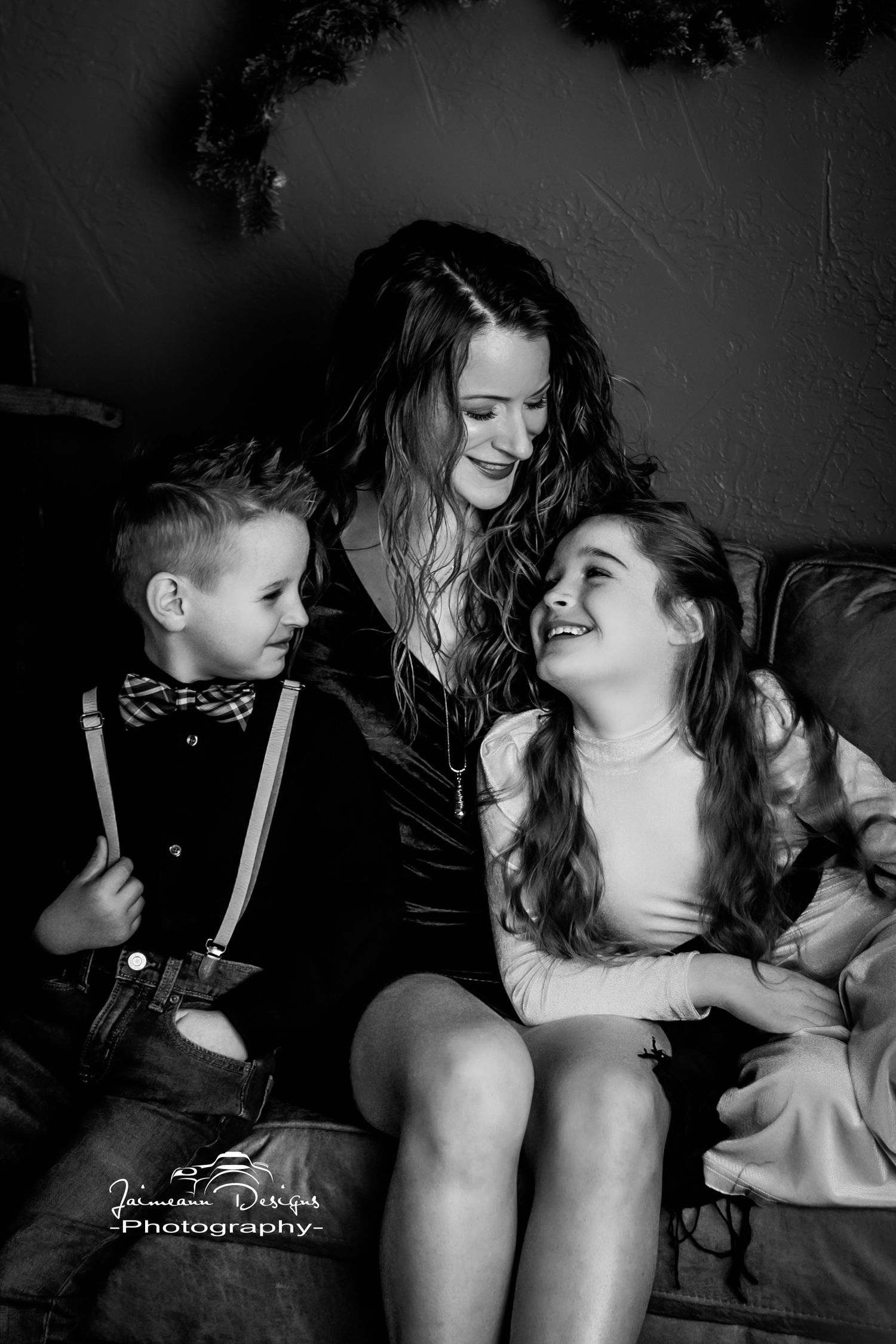 Black and white candid moment of joyful laughter on leather couch.