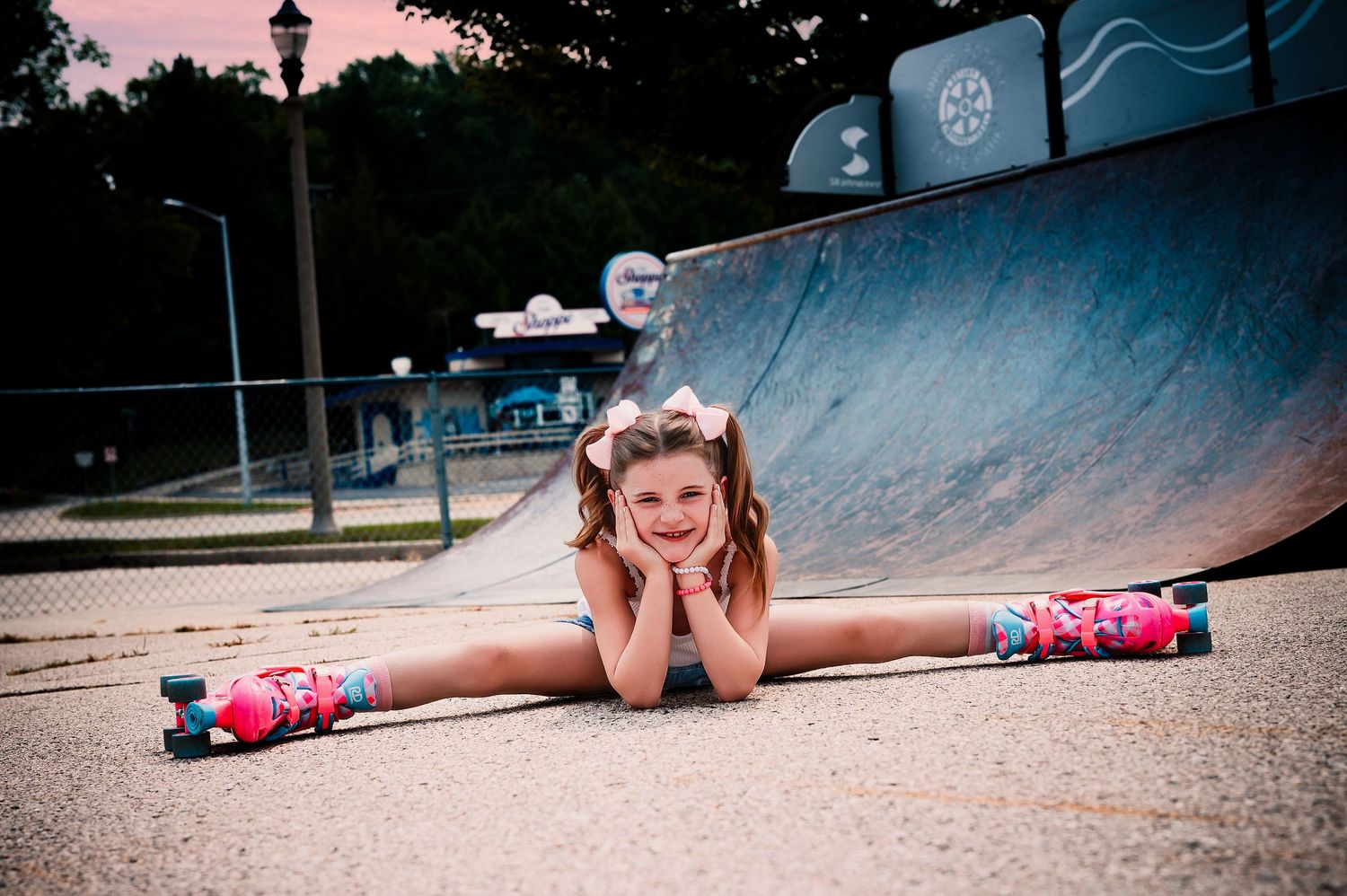 Roller skater does splits pose at skate park during sunset with pink sky and ramps in background, 8 Year Old Milestone Session, Cedarburg, W