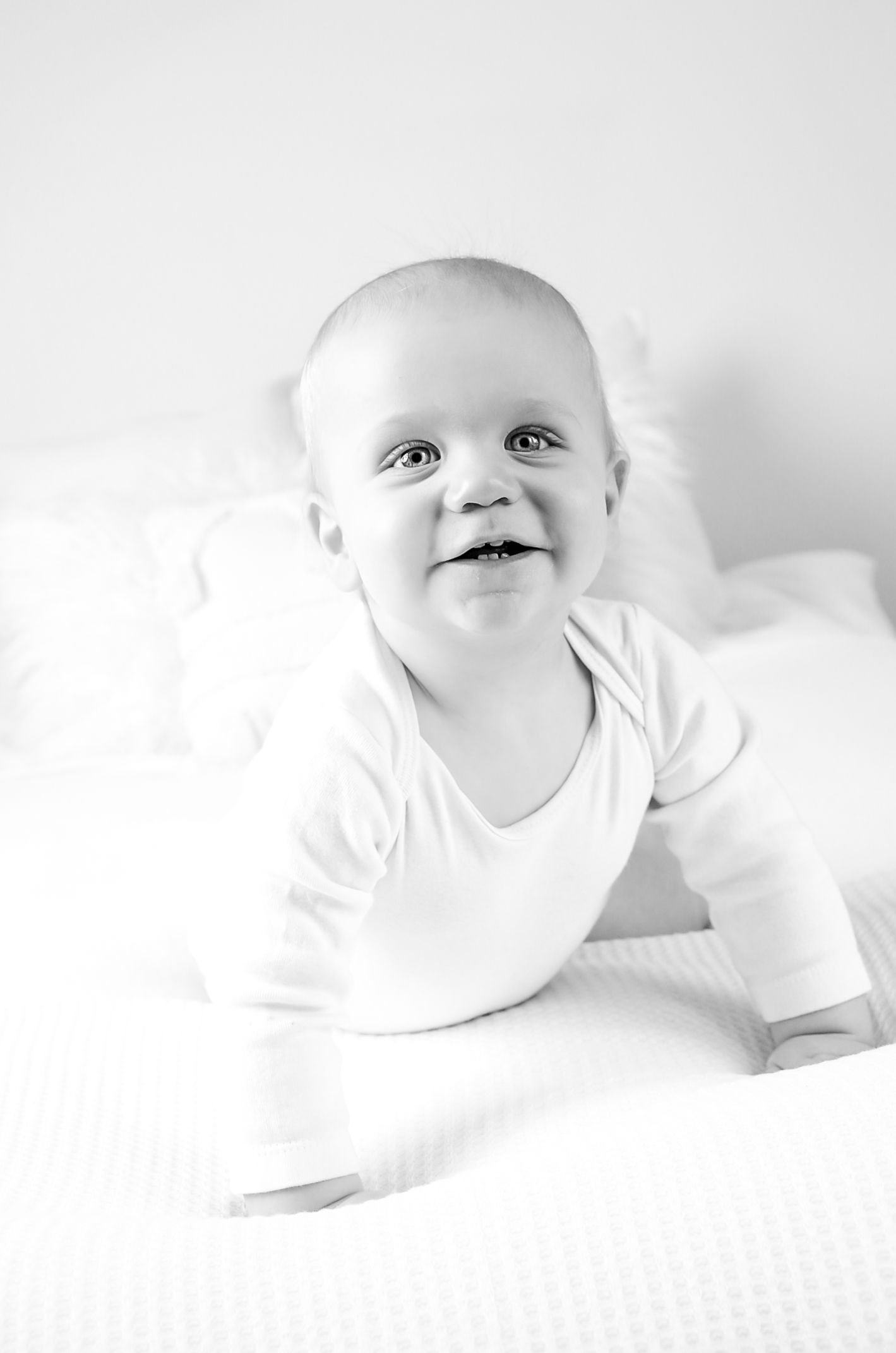 Simply white milestone year one session on bed with boy in Wisconsin Studio near Milwaukee, WI