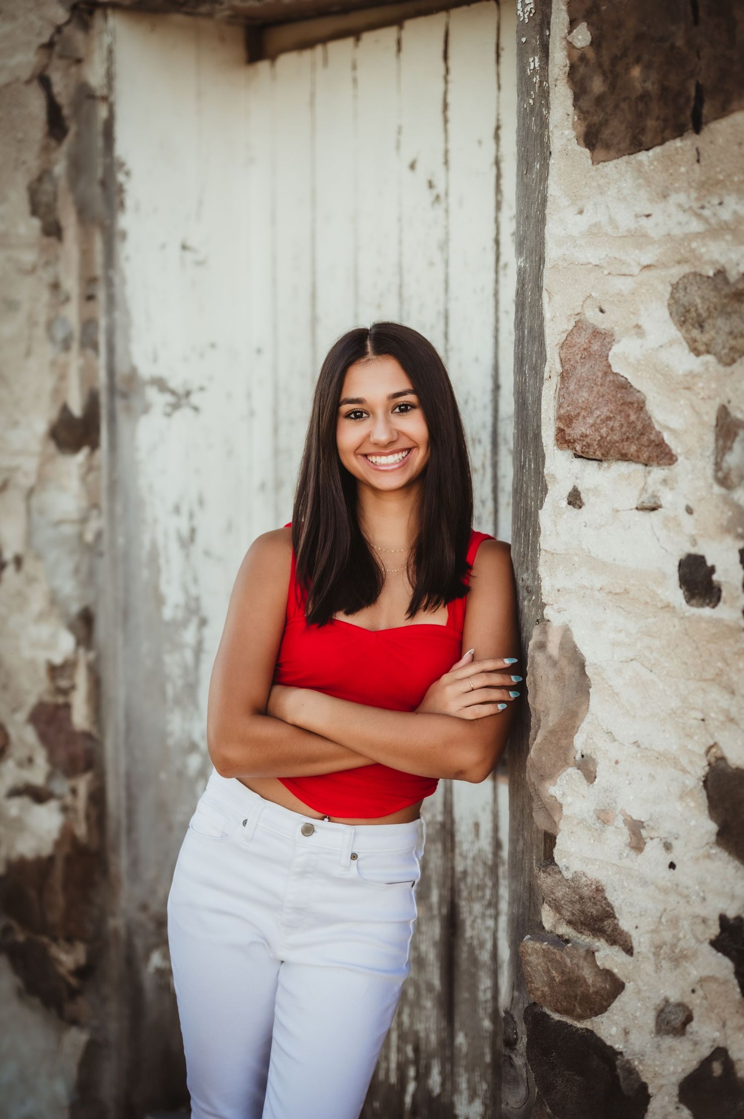 Fashion portrait against weathered stone wall and white door background.