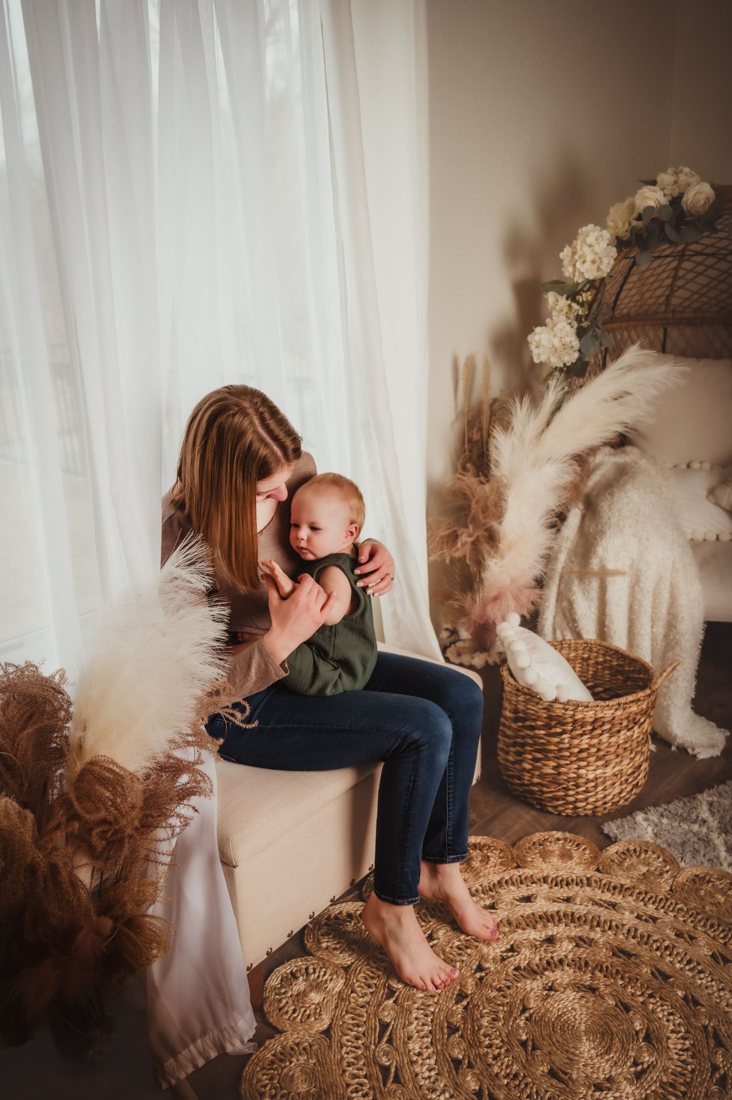 Intimate lifestyle portrait of tender moment between parent and baby in a cozy boho-styled room.
