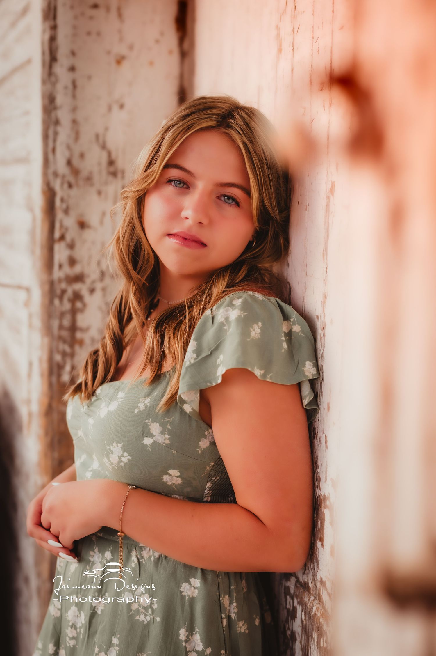 A warm-toned portrait against weathered wood featuring soft natural lighting.