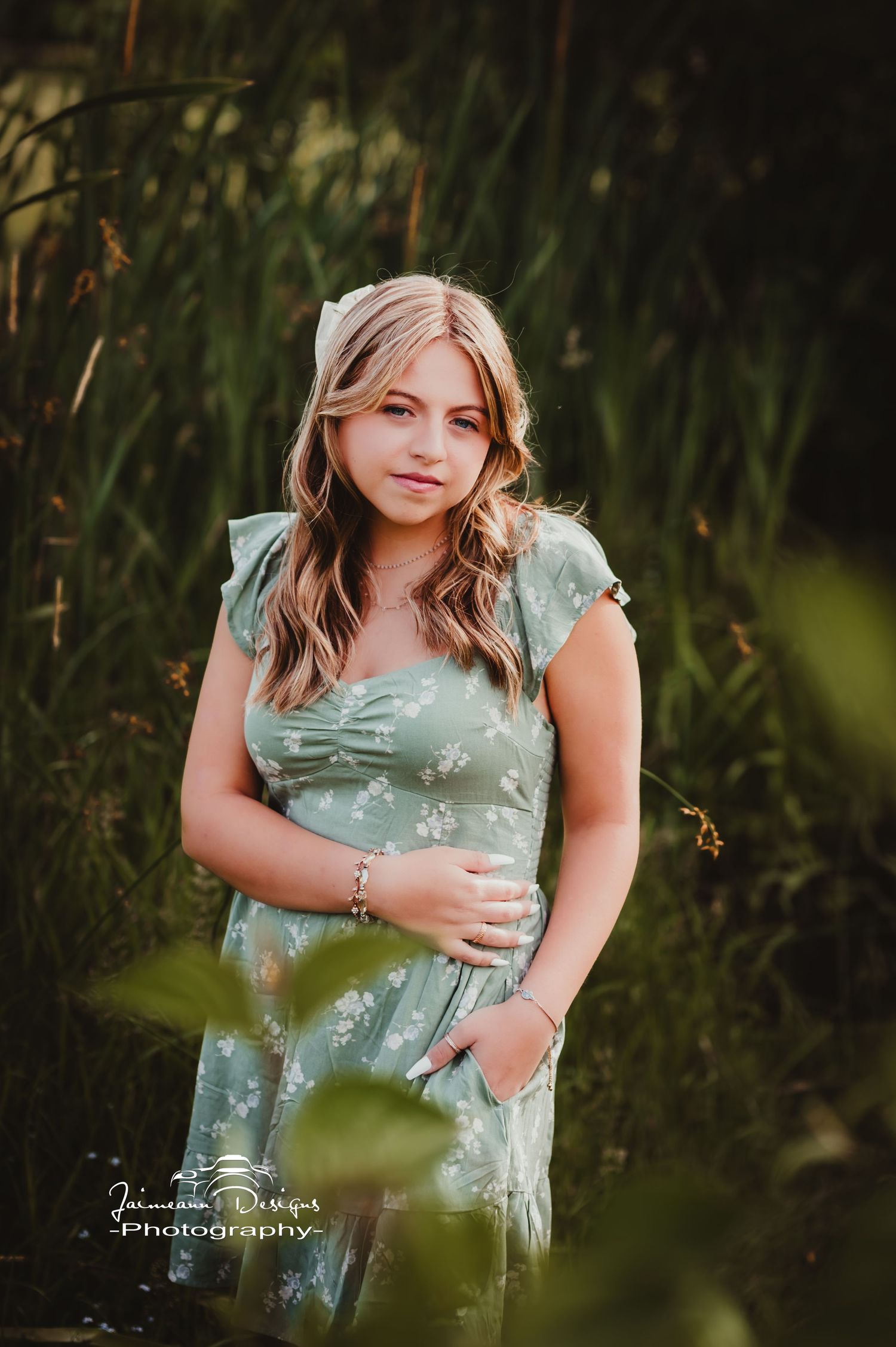 Outdoor portrait featuring a sage green floral dress with pockets in a garden setting.