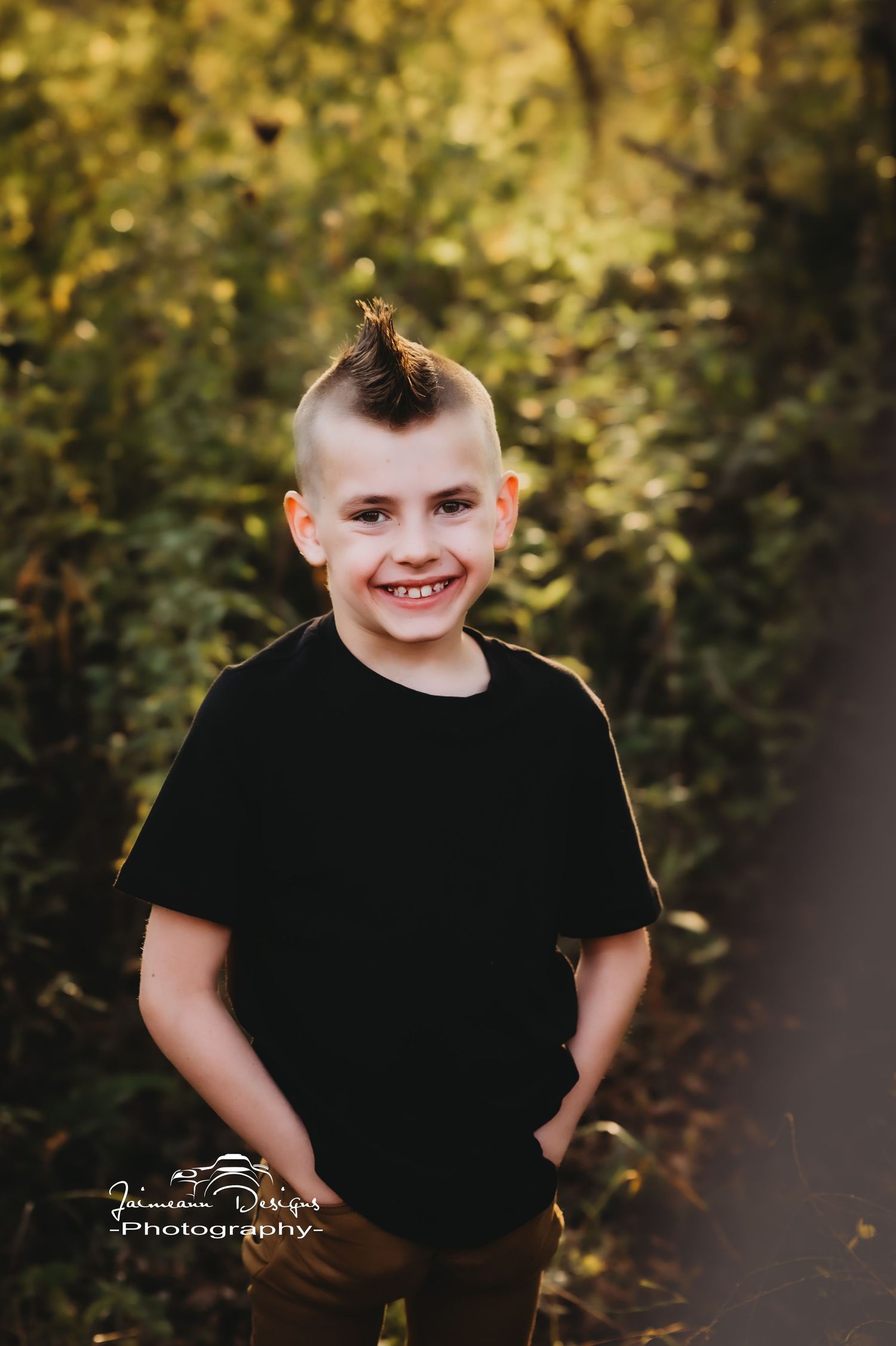 A joyful outdoor portrait with natural autumn foliage in the background.