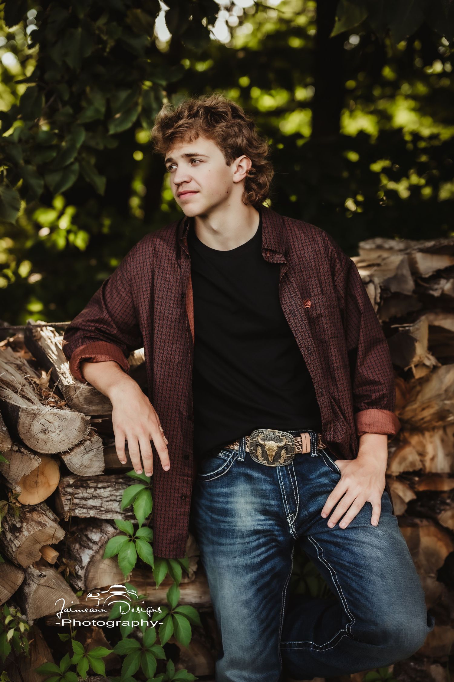 Modern casual portrait against stacked firewood background in natural lighting.