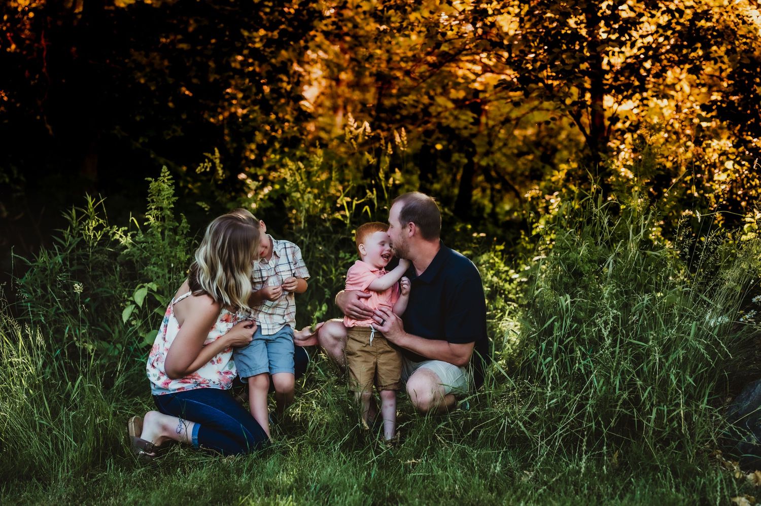 Family enjoying a tender moment together outdoors during golden hour.