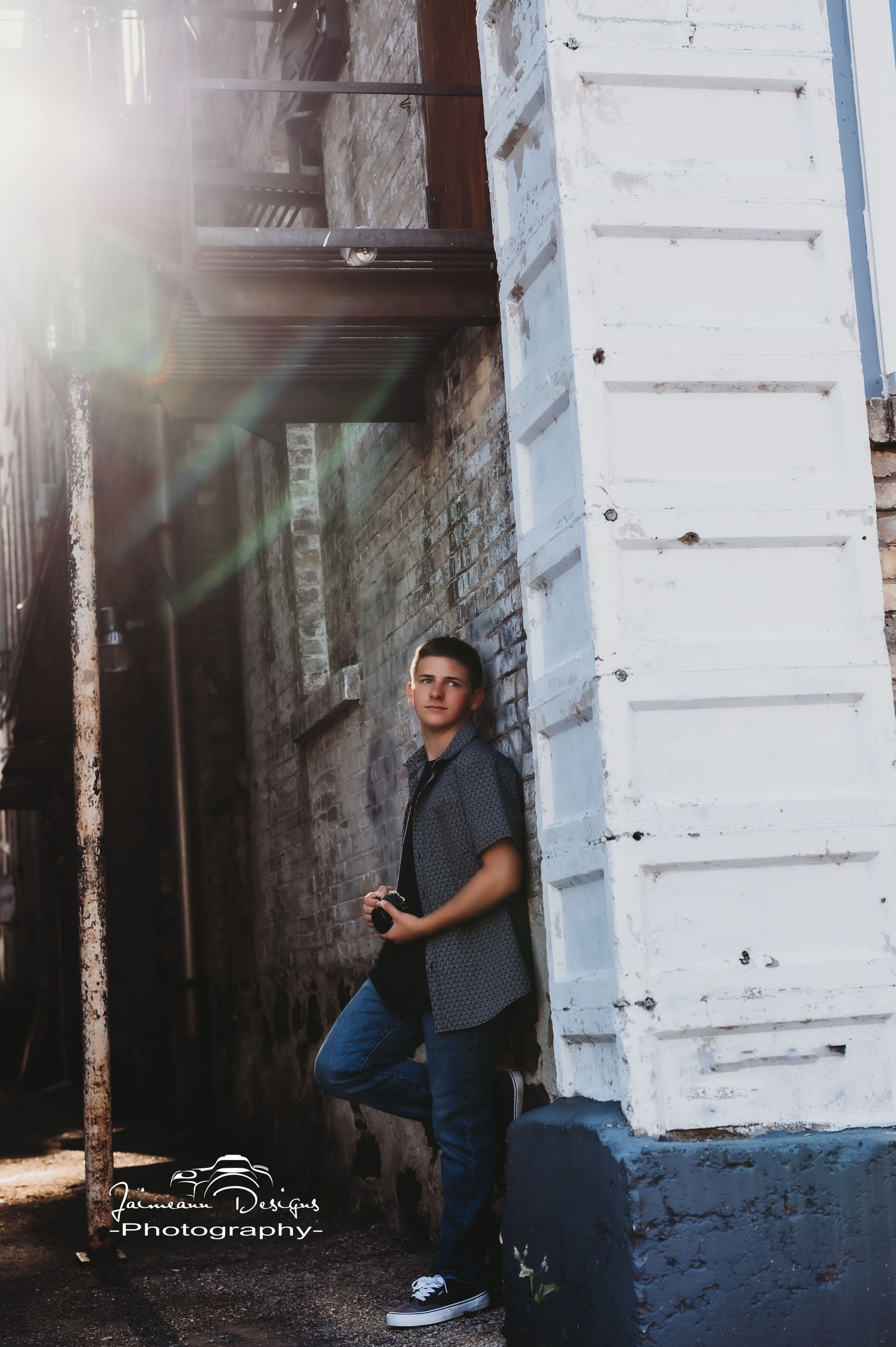 Moody portrait against white pillar with lens flare effect.